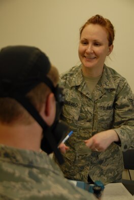 Tech. Sgt. Hannah Alvarado, 115th Medical Group bioenvironmental engineering technician, provides direction to Staff Sgt. Jeffrey Powers, 115 MDG aerospace medical technician, during his gas mask fit test at the Credit Union building on Truax Field on April 7. Alvarado was one of many gas mask fit test monitors trained to test masks at the 115th Fighter Wing. Approximately 1200 Airmen will need to be tested as they were recently issued the M50 gas masks. (Air National Guard photo by Andrea F. Liechti)