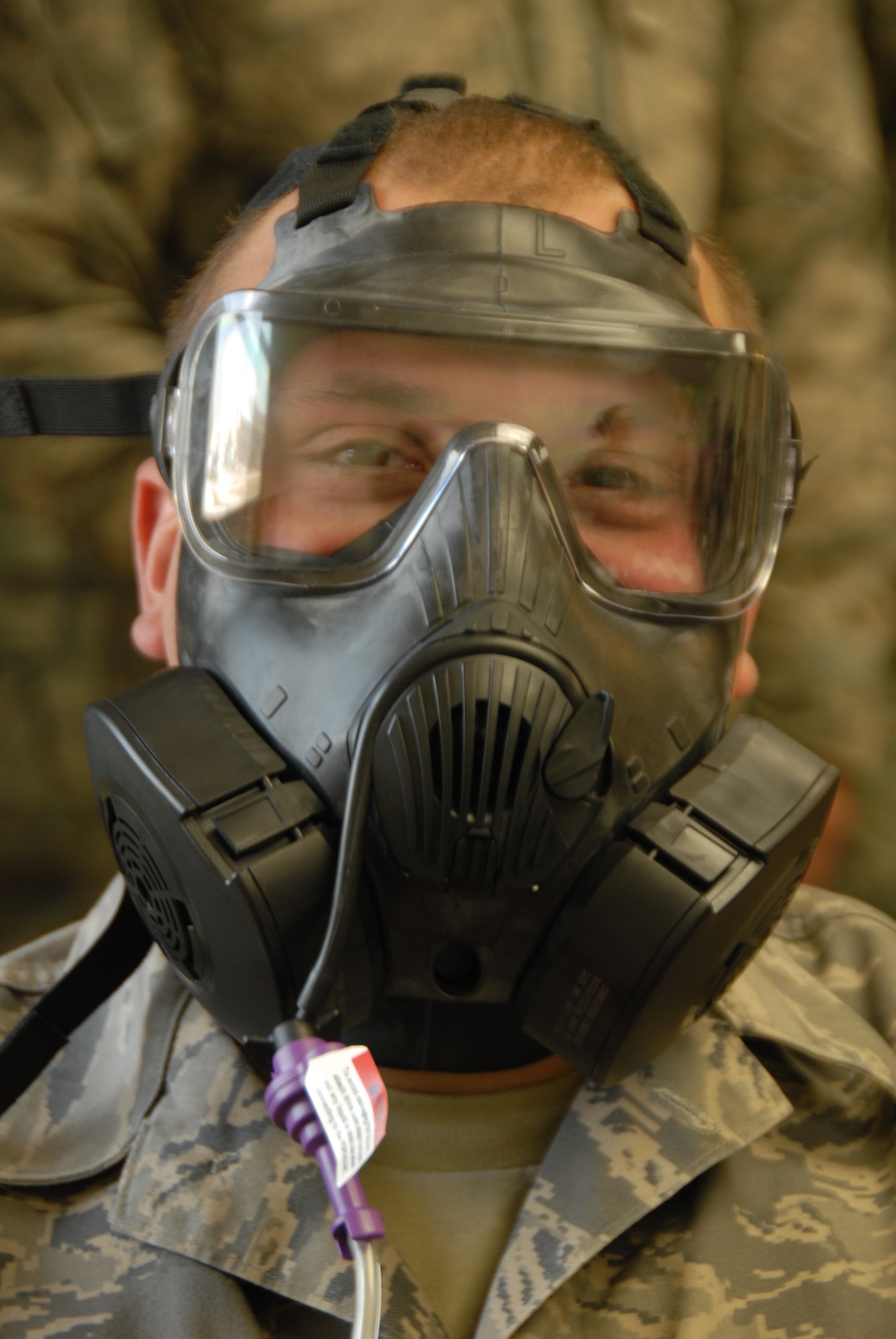 Senior Airman David Nelson, 115th Fighter Wing fuel shop, tests his gas mask for a good seal at the Credit Union building on Truax Field on April 7. Nelson used different breathing techniques and moved his head various directions to ensure his mask had a good seal throughout the testing. Airman at the 115th Fighter Wing just received the M50 gas masks and will all be required to accomplish the fit-tests on their masks. (Air National Guard photo by Andrea F. Liechti)