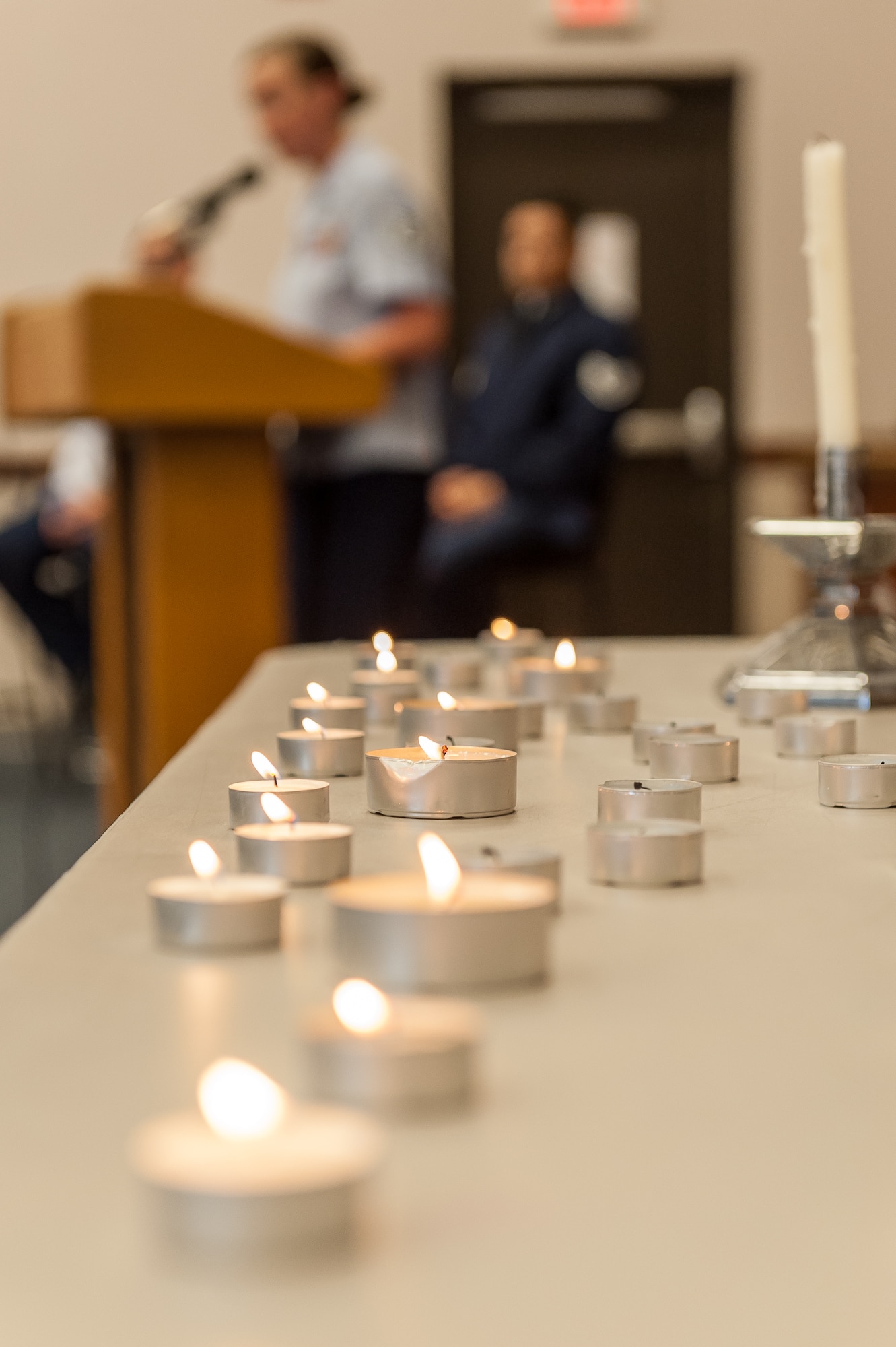 Staff Sgt. Anna Arbic, 65th Civil Engineer Squadron, reads names of Holocaust victims during a name-reading and candle-light vigil held in conjunction with the National Holocaust Days of Remembrance, at Lajes Field, April 8.  The 65th Air Base Wing held a formal ceremony commemorating the Holocaust, honoring the victims' memory and focusing on how Airmen stand against genocide and atrocities at Lajes Field, April 8. This year's national theme is "Never Again - Heeding the Warning Signs."  (Photo by Lucas Silva)     