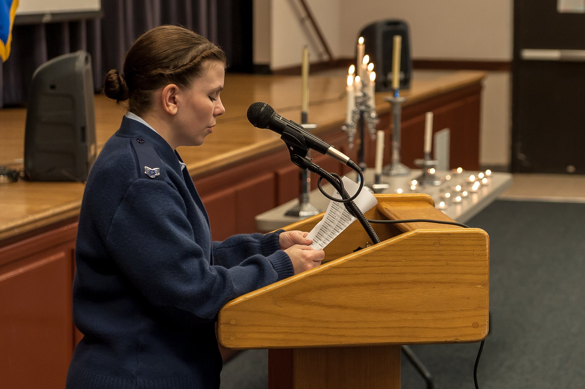 Staff Sgt. Angela Smith, 65th Medical Group, reads names of Holocaust victims during a name-reading and candle-light vigil held in conjunction with the National Holocaust Days of Remembrance at Lajes Field, April 8.  The 65th Air Base Wing held a formal ceremony commemorating the Holocaust, honoring the victims' memory and focusing on how Airmen stand against genocide and atrocities.  This year's national theme is "Never Again - Heeding the Warning Signs."      