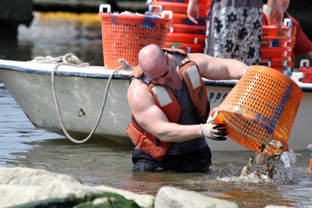 FORT NORFOLK, Va. -- Oceanographer Dave Schulte empties a bushel of oyster shell on the reef. Shell was donated by the Chesapeake Bay Foundation as well as collected by district volunteers at the Craney Island Eastward Expansion site in Portsmouth, Va. Each spring approximately 14,000 baby oysters are placed on the existing sanctuary reef off the shoreline of historic Fort Norfolk. Employees from the Norfolk District partnered with students from Seatack Elementary School in Virginia Beach in 2012 to build an oyster sanctuary along the shores of district’s property.