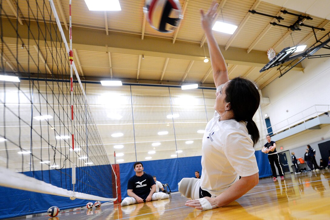 Navy Petty Officer 1st Class Linda Simpson, foreground, stretches to return a practice serve for the Navy's Warrior Games volleyball team before an exhibition game with the Penn State women's volleyball team in State College, Pa., April 5, 2013. Simpson is a mineman.