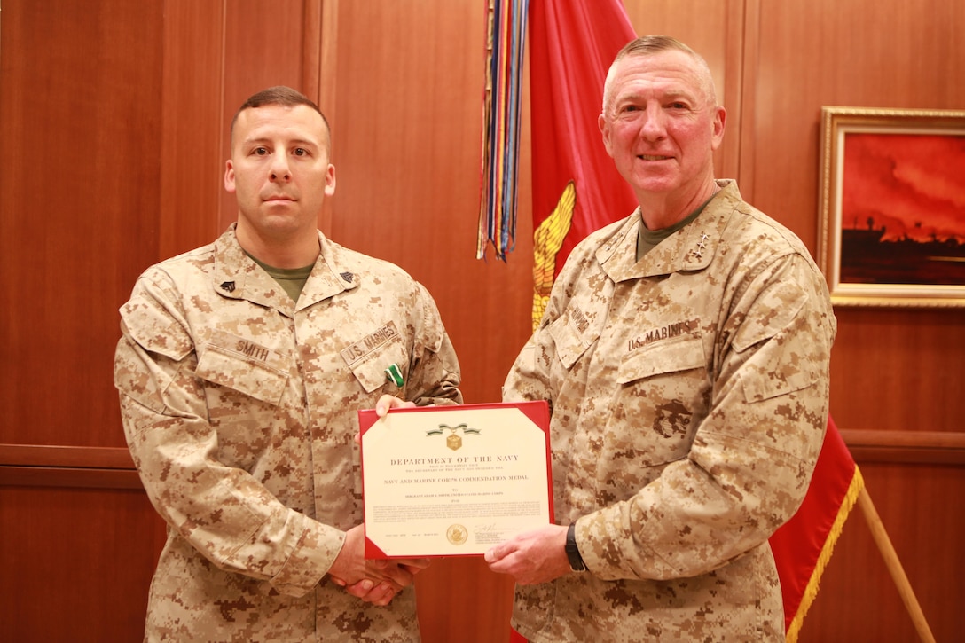 Lt. Gen. Steven A. Hummer, commander of Marine Forces Reserve and Marine Forces North, poses with Sgt. Adam K. Smith after presenting  him with a citation for his Navy and Marine Corps Commendation Medal at the Marine Corps Support Facility New Orleans, April 8, 2013. Smith, the repairable issue point chief for MARFORRES G4 (logistics and services), was awarded the medal after he was selected as the MARFORRES 2012 Marine of the Year (active component). 