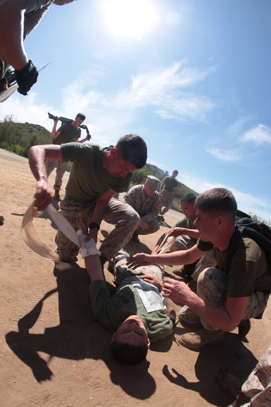 Marines with Maintenance Detachment, Combat Logistics Battalion 13, 13th Marine Expeditionary Unit, provide combat lifesaving measures to a simulated casualty during the “Lucky 13” Warrior Pentathlon aboard Marine Corps Base Camp PendletonMarch 28, 2013. The event also featured family activities for children, an appearance by an Easter Bunny, a barbeque and an award ceremony for the competition. (U.S. Marine Corps photo by Sgt. Christopher O’Quin/Released) 

