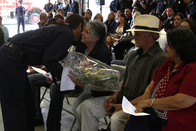 Daniel Bakker, a firefighter with the Camp Pendleton Fire Department presents Dorothy Tellez with a bouquet of flowers during the dedication ceremony of Pendleton’s Fire Station 10 held in honor of her son Sgt. Brian E. Dunlap here April 6. Dunlap was an advisor for the Iraqi Army and firefighter with the Camp Pendleton Fire Department and in 2005 and was killed by an improvised explosive device while conducting combat operations against enemy forces in Abu Fleiss, Iraq.