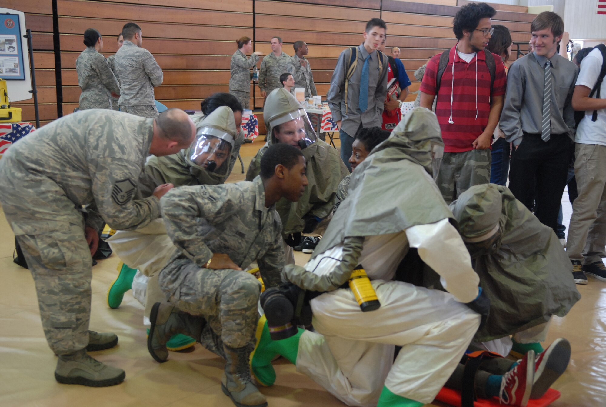 U.S. Airmen from the 18th Aerospace Medicine Squadron combine several medical specialties to simulate conditions during a chemical threat during the Kadena High School Career Day on Kadena Air Base, Japan, April 4, 2013. Hosted by the Air Force Cadet Officer Mentor Action Program, the purpose of the event was to offer a glimpse of Airmen's daily duties to possible recruits. (U.S. Air Force photo by Staff Sgt. Lauren Snyder/Released)
