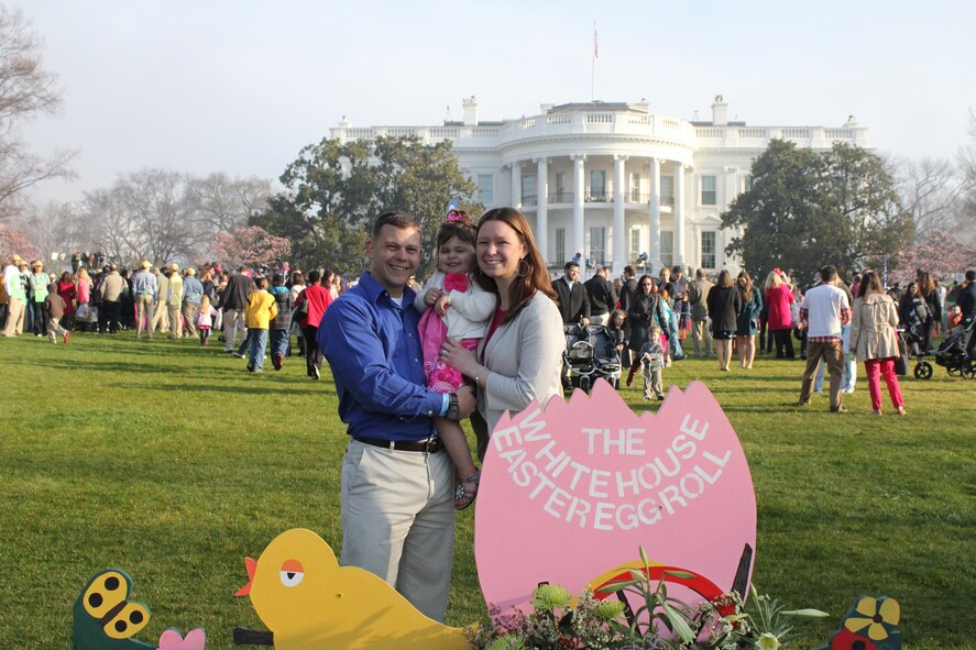 Staff Sgt. Nicole Green, Air Force District of Washington protocol, poses for a picture with her husband, Marine Staff Sgt. Jeff Green stationed at Marine Corps Base Quantico, Va., and their daughter at the White House Easter Egg Roll in Washington, D.C., April 1, 2013.  AFDW Airmen who deployed in the last 12 months, or are currently deployed, qualified for the opportunity for their family to attend the event. (Courtesy photo)