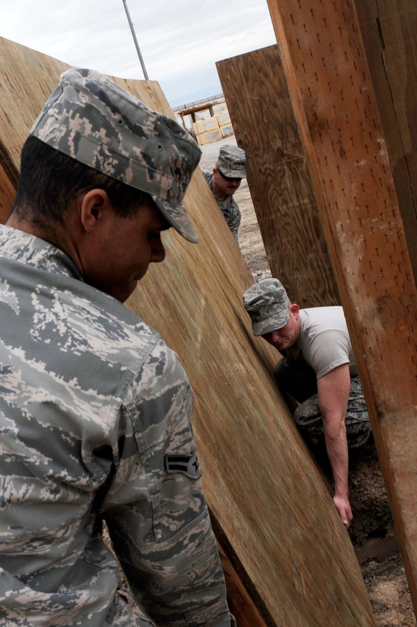 U.S. Air Force Airman 1st Class Nathan Coleman, Staff Sgt. Chris Carpenter and Staff Sgt. Kyle McCloskey, 366th Civil Engineer Squadron structures technicians, put in place a revetment wall at a simulated deployed location, Mountain Home Air Force Base, Idaho, April 1, 2013. The walls of the revetment need to be located close to the asset without being inaccessible.  (U.S. Air Force photo/Staff Sgt. Roy Lynch) (Released)