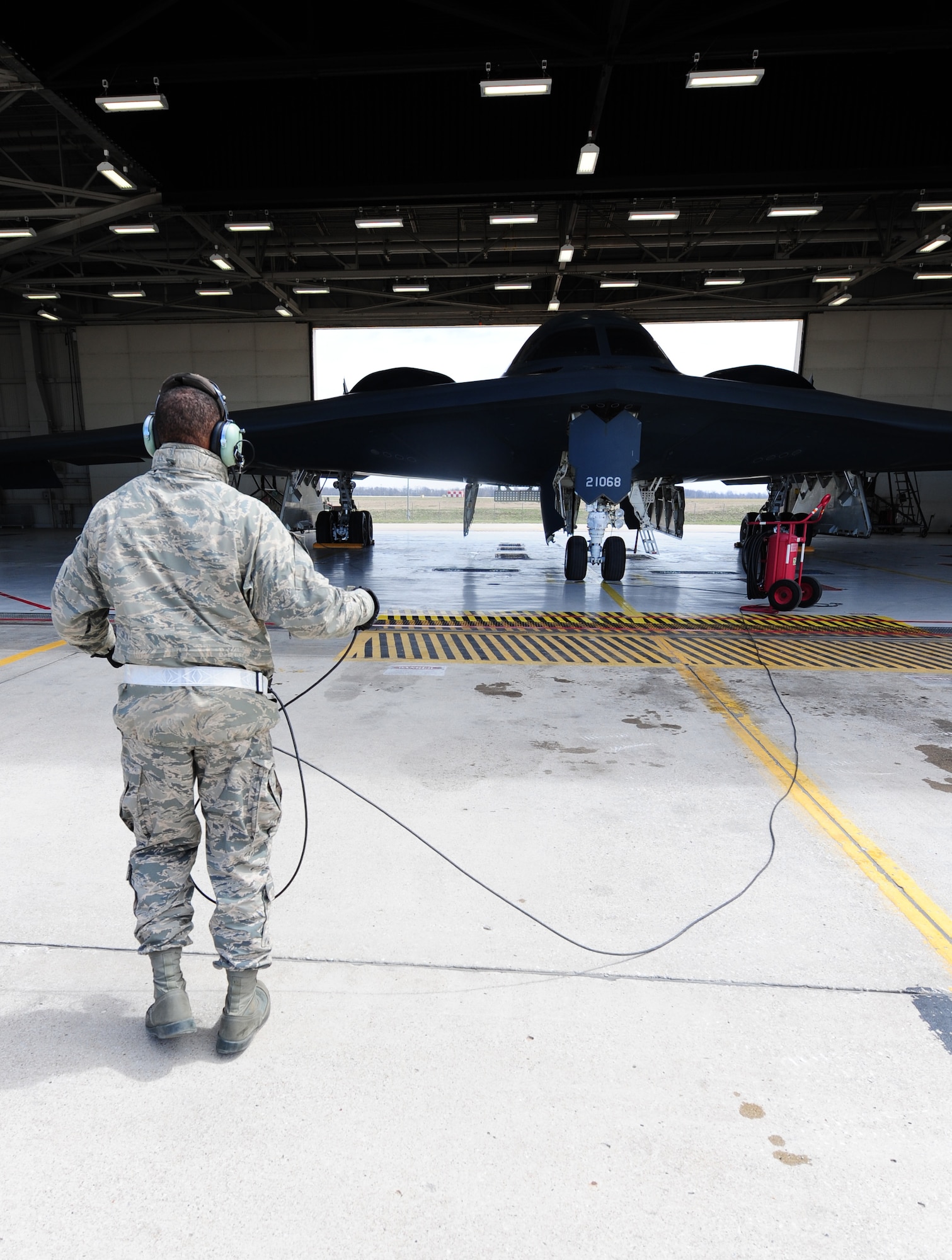 Airman 1st Class Steven McCray, 13th Aircraft Maintenance Unit B-2 Spirit crew chief, speaks to his pilots with a communications cord during a pre-flight inspection at Whiteman Air Force Base, April 5, 2013. Pilots and crew chiefs conduct pre-flight inspections to ensure all components of the jet are mission-capable before flight. (U.S. Air Force photo by Staff Sgt. Nick Wilson/Released)