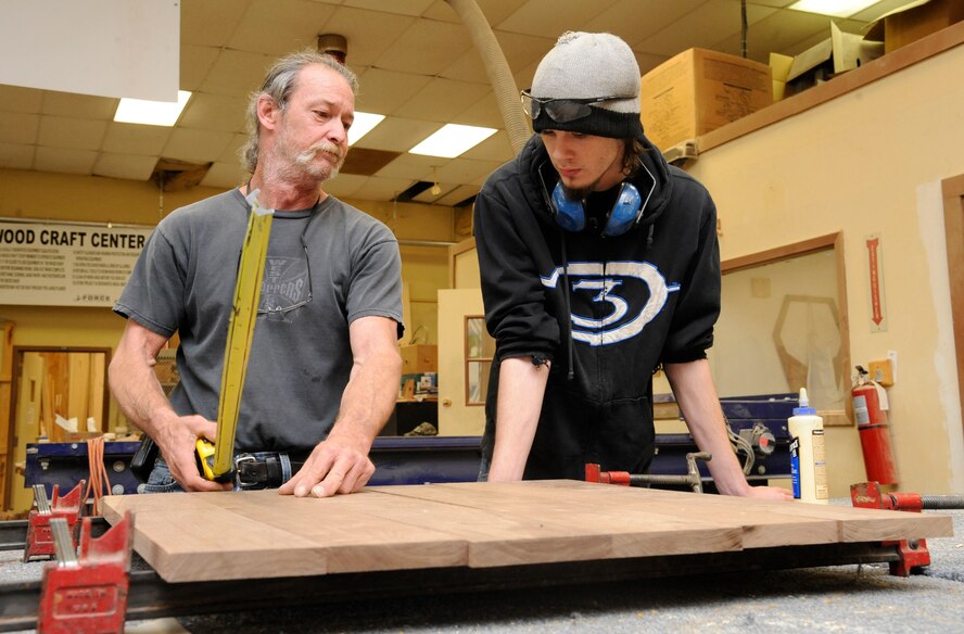 Mike Jarrett and Tyler Tessada, 2nd Force Support Squadron woodcrafts center, inspect planks of wood before beginning the construction of a shadowbox on Barksdale Air Force Base, La., April 10, 2013. The wood craft shop makes shadow boxes, podiums, trophy cases and coin racks. Every month, the wood craft shop offers a four-day woodworking class where beginners can be certified to use woodworking equipment. (U.S. Air Force photo/Airman 1st Class Andrew Moua)