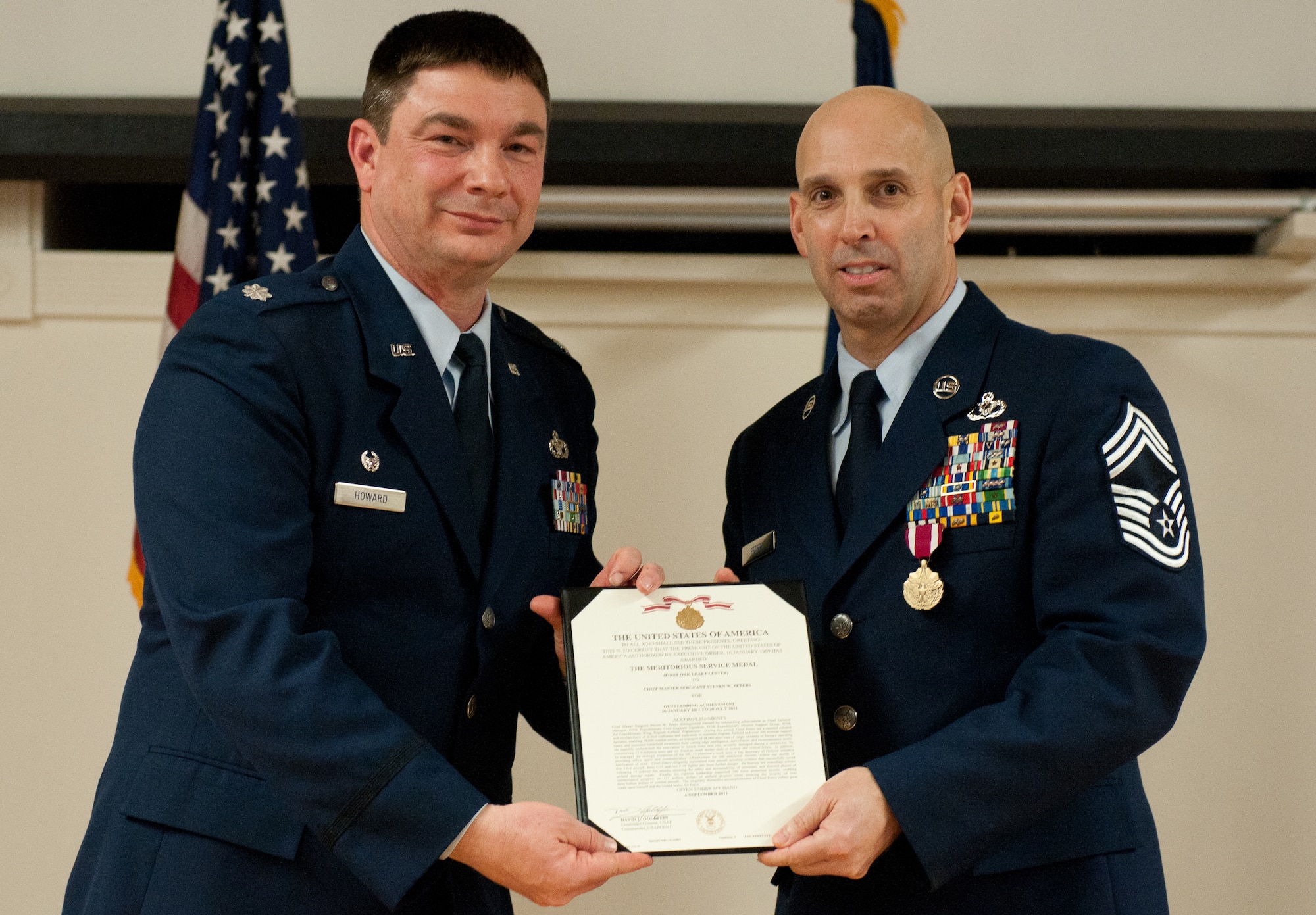 Chief Master Sgt. Steven Peters (right) is presented with a Meritorious Service Medal by Lt. Col. Phil Howard, commander of the 123rd Civil Engineer Squadron, during a retirement ceremony held in Peters’ honor at the Kentucky Air National Guard Base in Louisville, Ky., on Feb. 2, 2013. Peters, the squadron’s chief of operations, served in the active-duty Air Force and Air National Guard for three decades. (U.S. Air Force photo by Airman Joshua Horton)