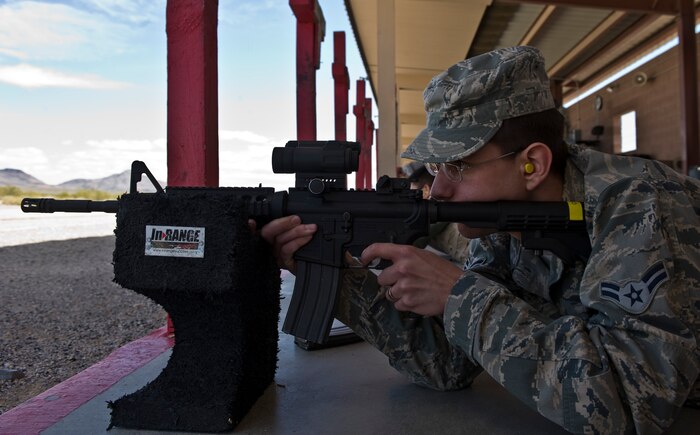 Airman 1st Class Joseph Hammersten, 99th Force Support Squadron food service worker, shoots an M4 carbine assault rifle during a combat arms training and maintenance class April 9, 2013, at Nellis Air Force Base, Nev. The M4 carbine assault rifle is a gas-operated, magazine-fed, selective fire, shoulder-fired weapon with a telescoping stock. (U.S. Air Force photo by Senior Airman Matthew Lancaster)