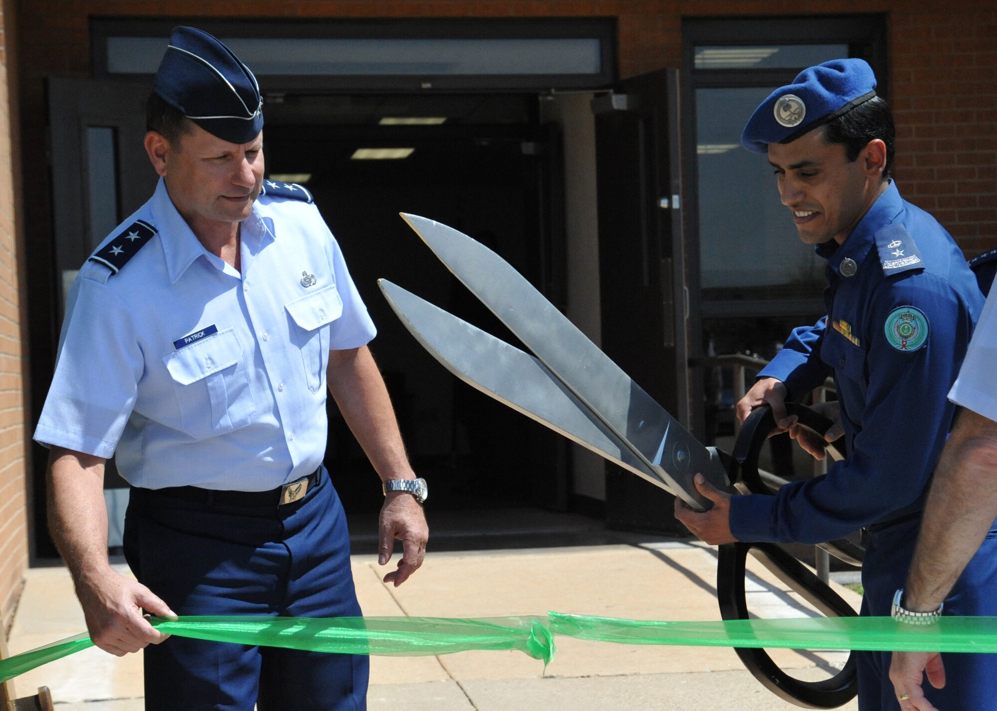 Maj. Gen. Leonard Patrick (left) and Royal Saudi Air Force Lt. Col. Abdulrahman Alkhmees cut the ribbon at the official opening of the RSAF Country Liason Office here April 8. The renovated Country Liaison Office and nearby dorms will be used to support increased RSAF technical training at Sheppard. (U.S. Air Force photo/2nd Lt. Meredith Hein)
