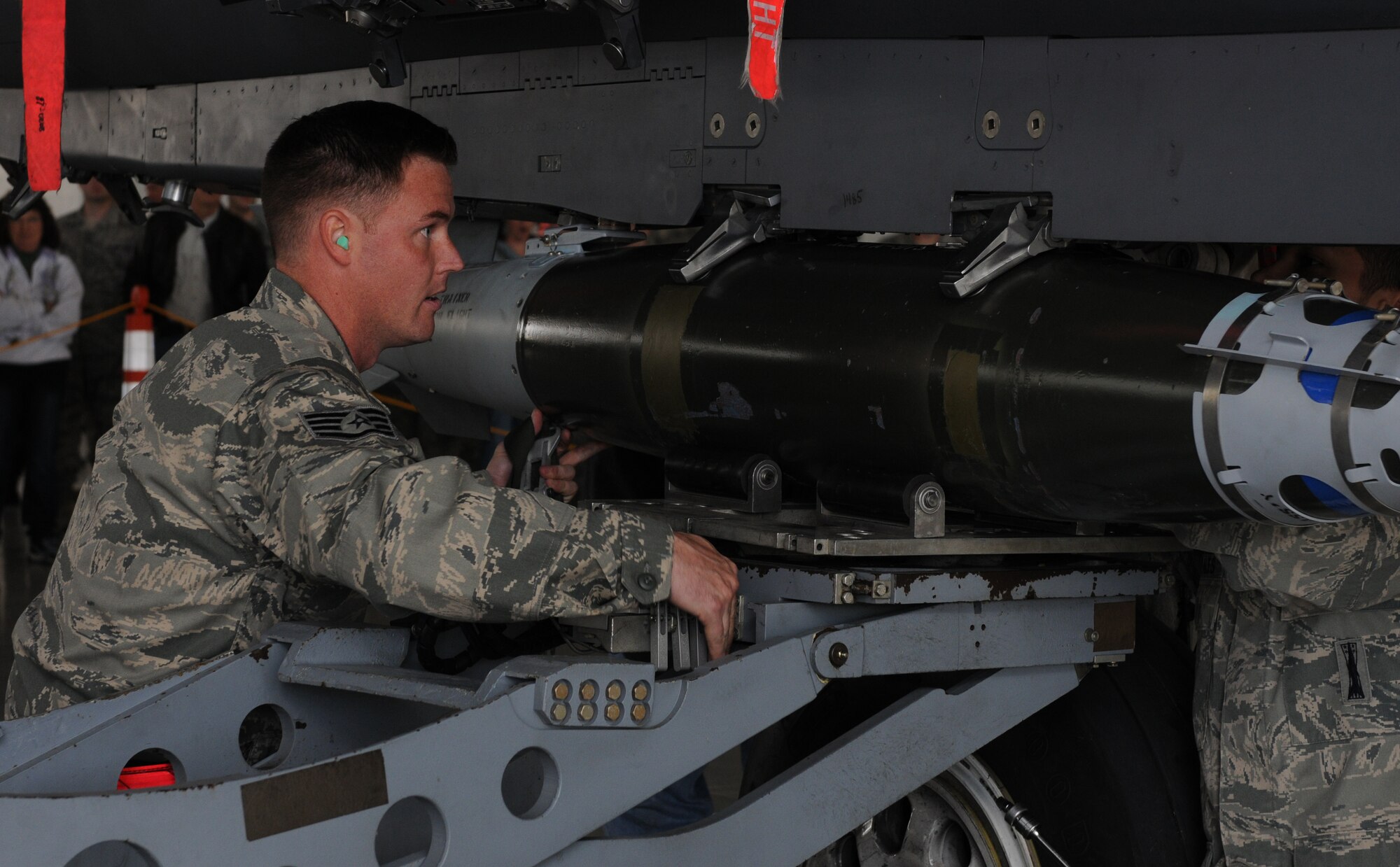 U.S. Air Force Staff Sgt. John Fergus, 389th Aircraft Maintenance Unit weapons load team crewman, attaches a weapon to an F-15E Strike Eagle during weapons load competition at Mountain Home Air Force Base, Idaho, April 5, 2013. The weapons load competition is held quarterly and tests speed and accuracy to ensure combat readiness. (U.S. Air Force photo/Senior Airman Heather Hayward)