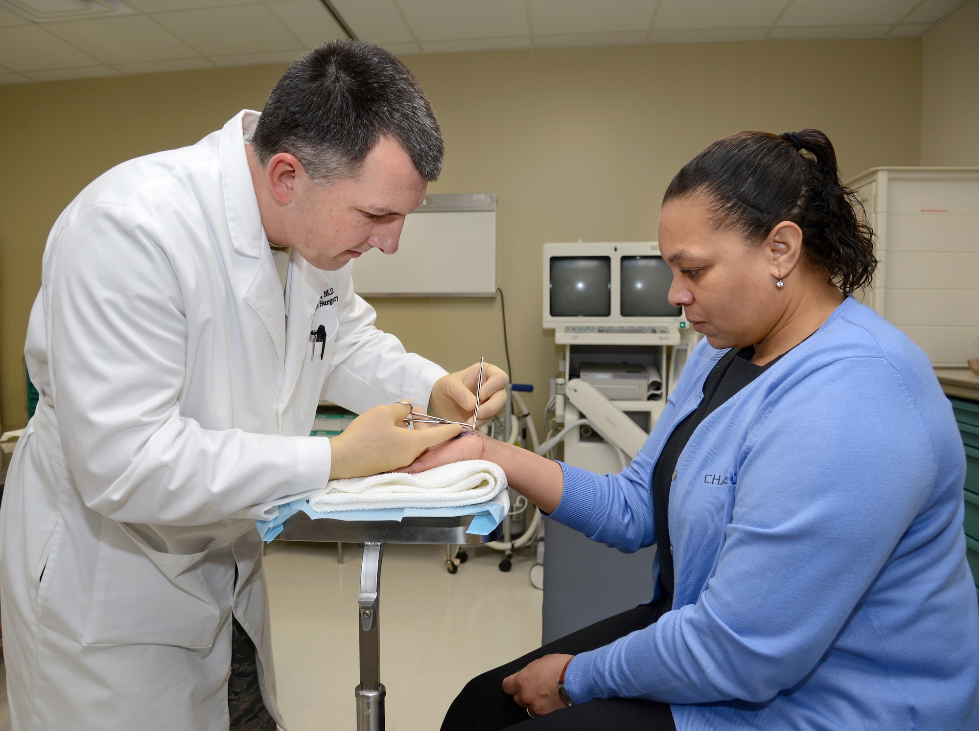 Lt. Col. (Dr.) Dennis Bond, an orthopedic surgeon in the 72nd Medical Group’s Orthopedic Clinic, removes sutures from Virginia Hoskins, an Army dependent, after her recovery from carpal tunnel surgery. (Air Force photo by Kelly White)