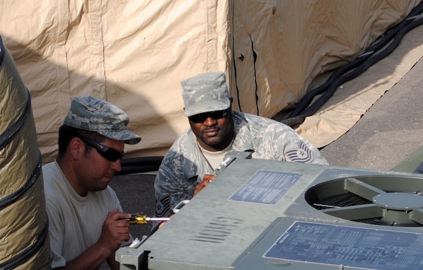 Master Sgt. Alex Torres, left, and Tech. Sgt. Johnny Gordon of the 55th Combat Communications Squadron, Robins Air Force Base, Ga., perform maintenance on a communications equipment cooling unit in support of African Lion 2013 in Morocco on April 9. African Lion is an annually scheduled, bilateral U.S. and Moroccan sponsored exercise designed to improve interoperability and mutual understanding of each nation's tactics, techniques and procedures. This year, the 55th CBCS was selected to provide communications support for the exercise. (U.S. Air Force photo by SrA. Will Toussaint)