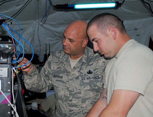 Master Sgt. Lou Bouffard and Staff Sgt. Michael Russano of the 55th Combat Communications Squadron, Robins Air Force Base, Ga., configure settings on network servers in support of African Lion 2013 in Morocco on April 9. African Lion is an annually scheduled, bilateral U.S. and Moroccan sponsored exercise designed to improve interoperability and mutual understanding of each nation's tactics, techniques and procedures. This year, the 55th CBCS was selected to provide communications support for the exercise. (U.S. Air Force photo/SrA. Will Toussaint)