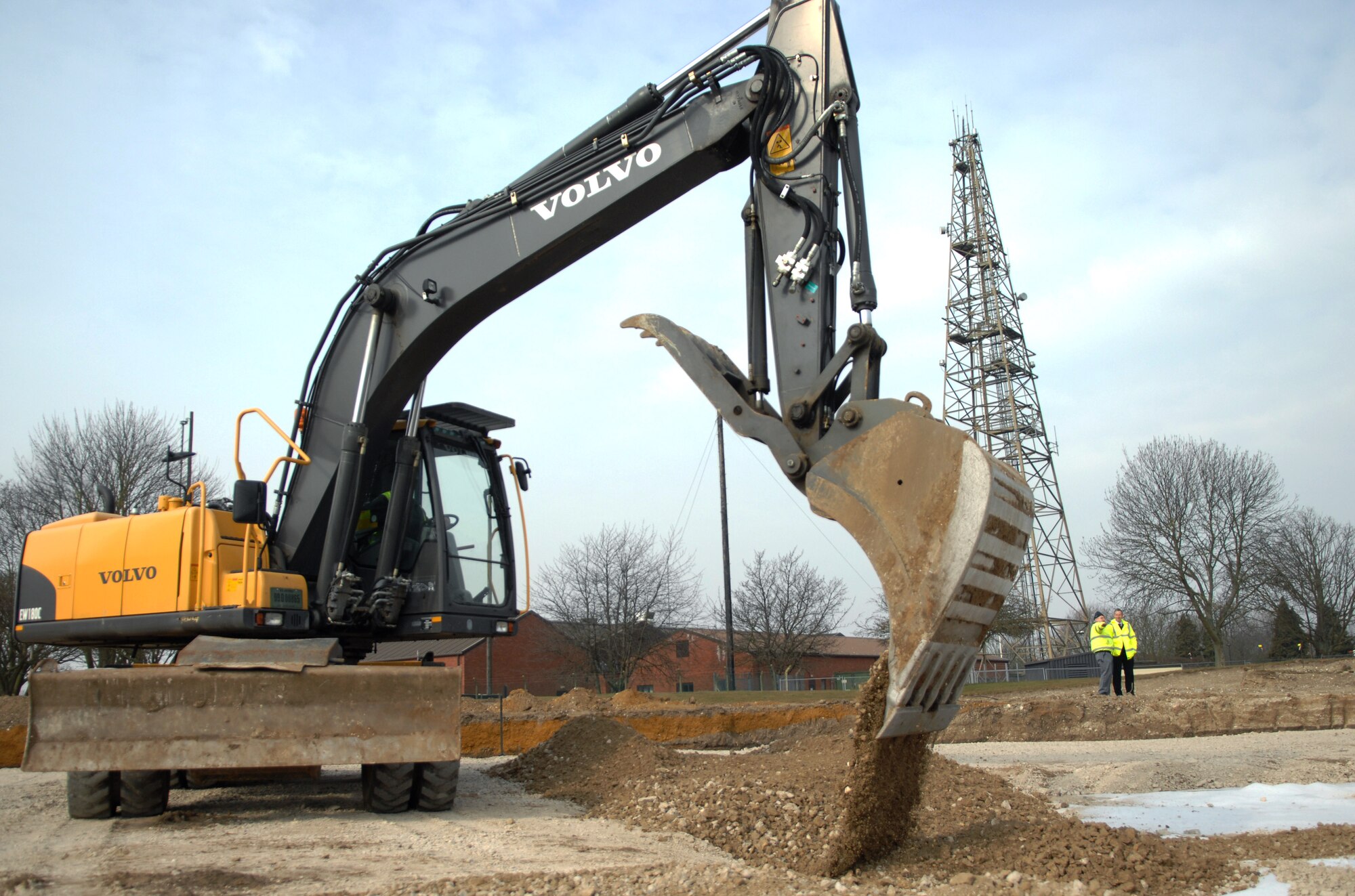 A construction worker from the 38th Construction Training Squadron, Ramstein Air Base, Germany, operates an excavator during construction of a new parking lot April 9, 2013, behind building 591 on RAF Mildenhall, England. The 38th CTS started construction February 2013, and is slated to finish July 2013. The parking lot will have a capacity of 75 vehicles to give the staff of building 591 more room for parking as building occupancy increases. (U.S. Air Force photo by Airman 1st Class Dillon Johnston/Released)