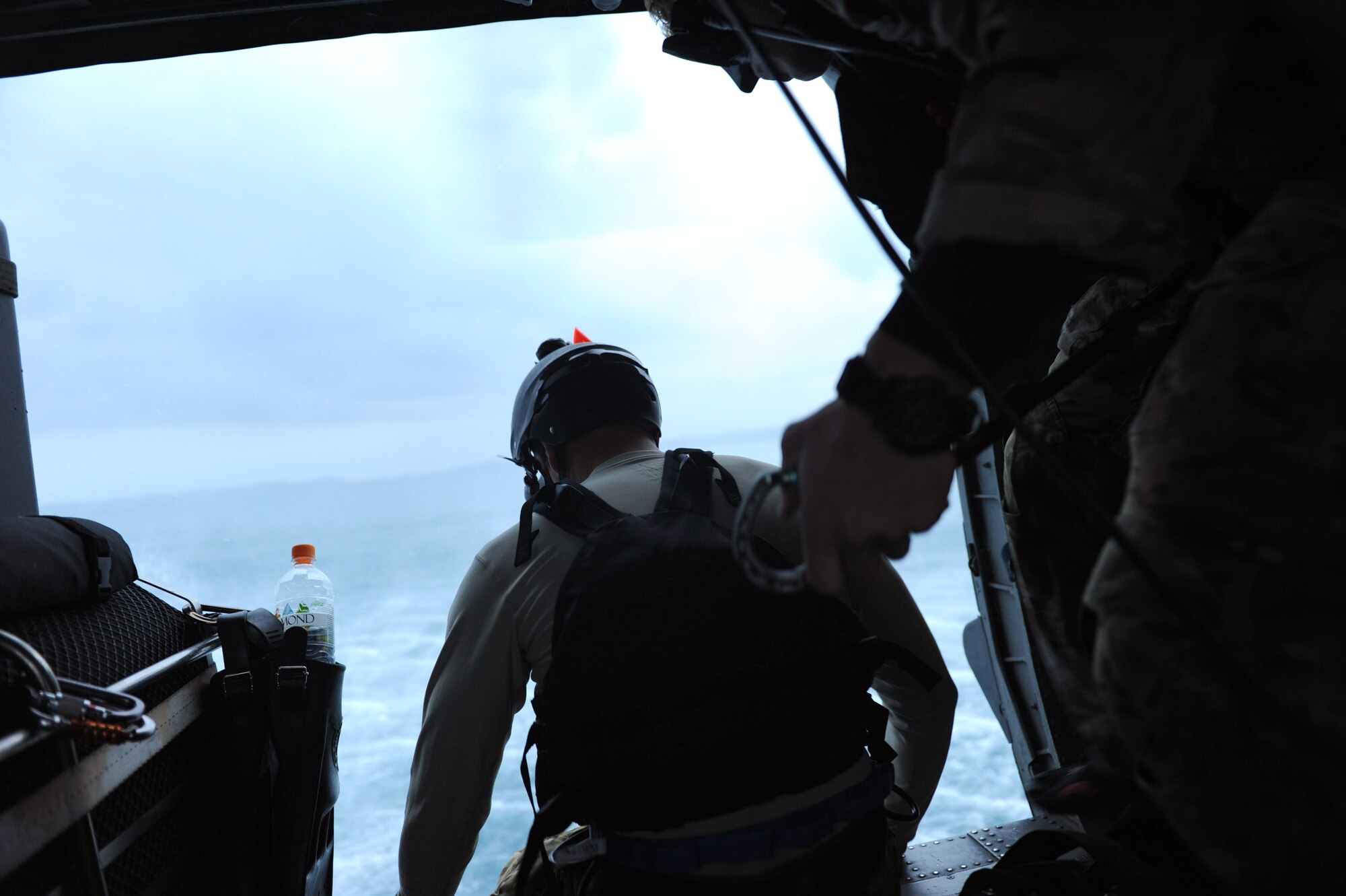 U.S. Air Force Brig. Gen. Matt Molloy, 18th Wing commander, and pararescuemen from the 31st Rescue Squadron prepare to jump out of an HH-60 Pave Hawk helicopter on Kadena Air Base, Japan, April 9, 2013. Molloy joined the 31st and 33rd Rescue Squadrons for a final flight before his change of command in May. (U.S. Air Force photo by Airman 1st Class Hailey R. Davis)