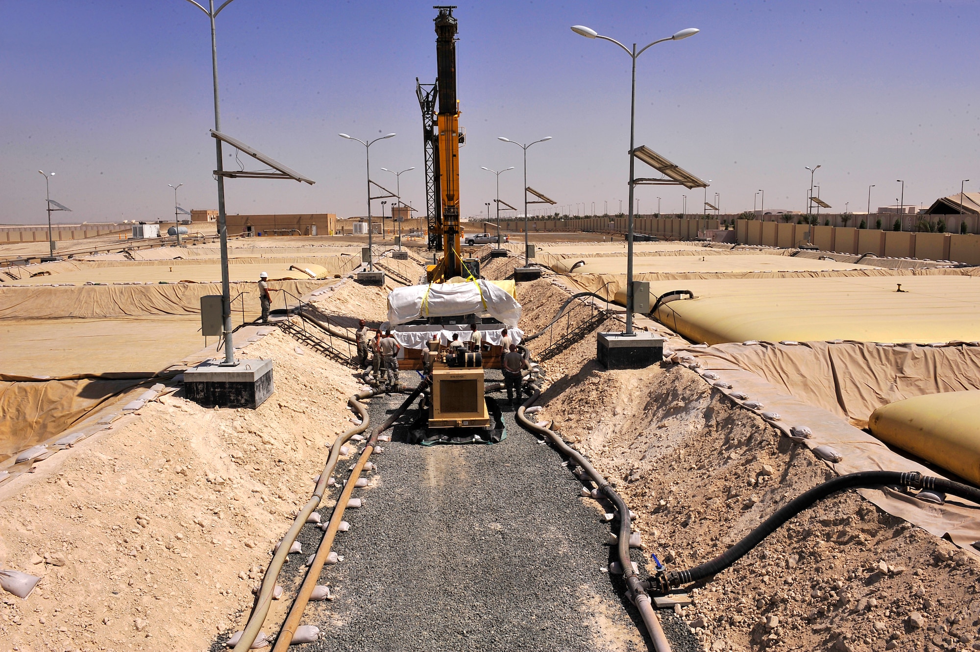 Airmen assigned to the 380th Air Expeditionary Logistics Readiness Squadron fuels flight replace a 200,000 gallon fuel bladder at an undisclosed location in Southwest Asia April 2, 2013. Sixty Airmen operate the fuels farm, moving anywhere from 300,000 to 600,000 gallons of fuel each day. (U.S. Air Force photo by Tech. Sgt. Christina M. Styer/Released)