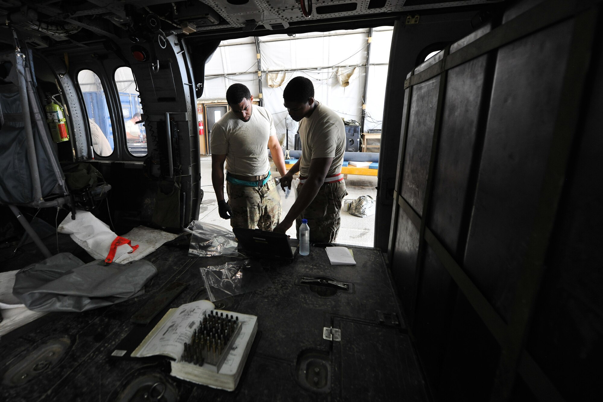 Staff Sgt. Bernard Williams and Senior Airman Clinton Austin, both 455th Expeditionary Aircraft Maintenance Squadron 83rd Helicopter Maintenance Unit crew chiefs, review the maintenance procedures for a HH-60 Pave Hawk helicopter on Bagram Airfield, Afghanistan, April 9, 2013. The helicopter maintainers work a non-stop alert schedule to maintain high mission-capable ratings and are ready to respond 24 hours a day, seven days a week. (U.S. Air Force photo/Senior Airman Chris Willis)