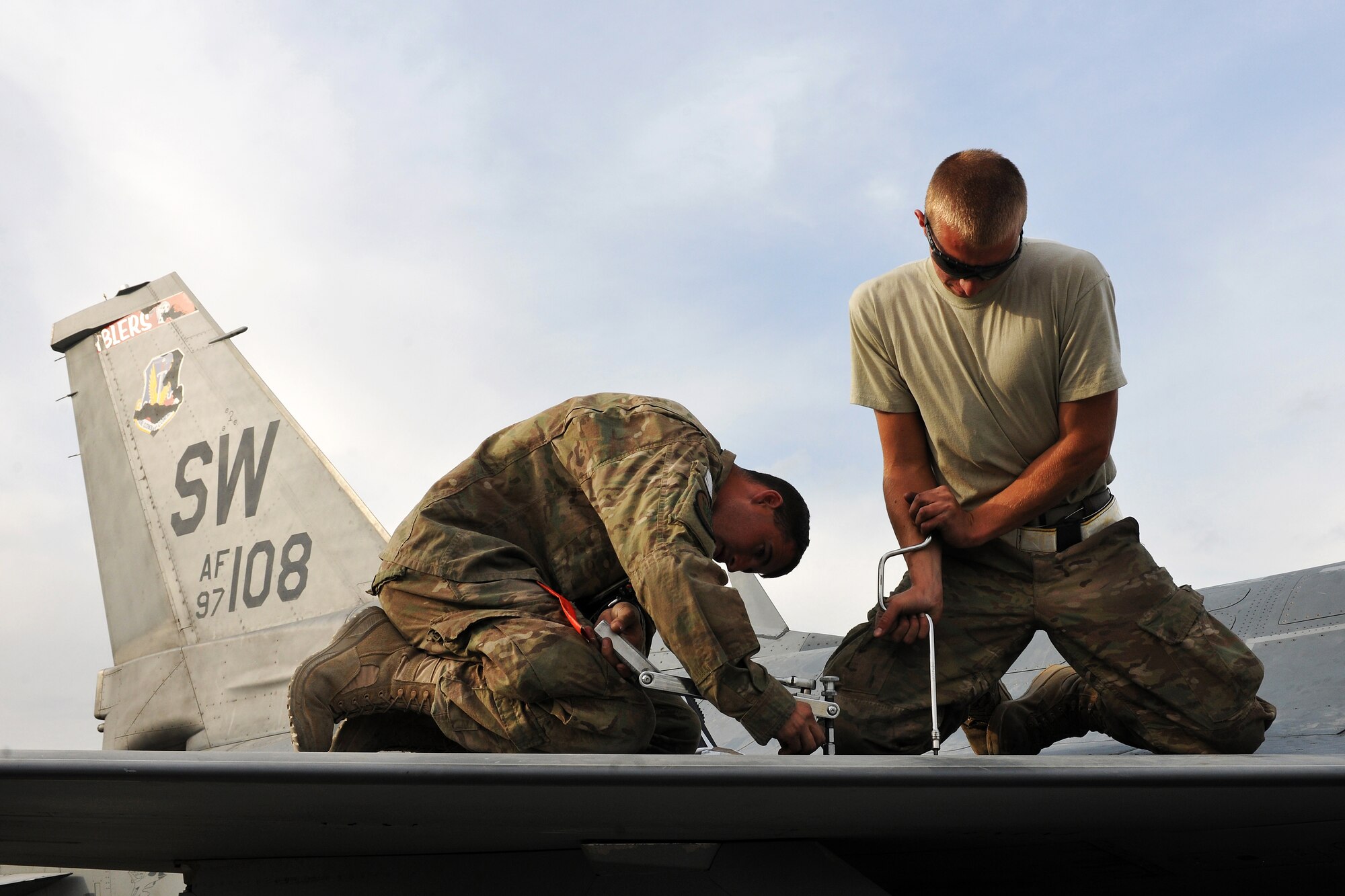 Senior Airmen Matthew House and Max Stammer, crew chiefs deployed from Shaw Air Force Base, S.C., replace a panel on an F-16 Fighting Falcon during a post flight inspection at Bagram Airfield, Afghanistan, Apr. 6, 2013. The aircraft receive inspections before takeoff and after landing to ensure the safety of the aircraft and pilot. (U.S. Air Force photo/Senior Airman Chris Willis)