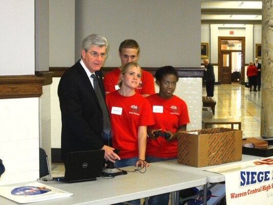 Mississippi Gov. Phil Bryant receives a lesson on robot mobility from members of Team 456.