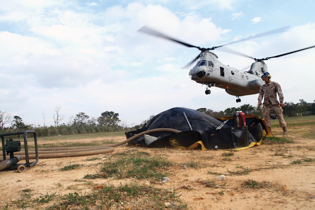 Pfc. Anthony F. Paderes prepares to refuel a CH-46E Sea Knight helicopter landing at a forward-arming and refueling point April 3 at the Central Training Area near Camp Hansen. At a FARP, helicopters can refuel without having to shut off their engines. The helicopter is with HMM-262. Paderes is a bulk fuel specialist with MWSS-172. Photo by Lance Cpl. Nicholas S. Ranum