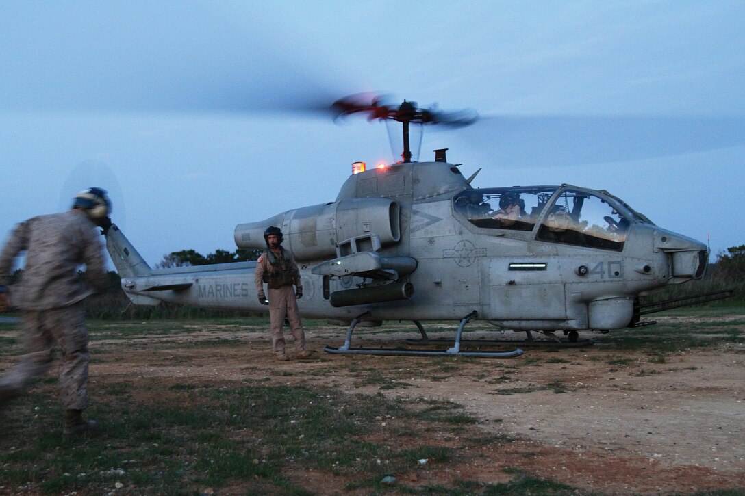 Marines prepare to refuel an AH-1W Super Cobra helicopter during a forward-arming and refueling point training exercise April 3 at the Central Training Area. Upon landing, the Cobra was refueled as part of an exercise to familiarize Marines with the procedures for refueling a helicopter while the engine is still running in order to expedite the aircraft’s return to the air. The helicopter is a part of HMM-262. Photo by Lance Cpl. Nicholas S. Ranum