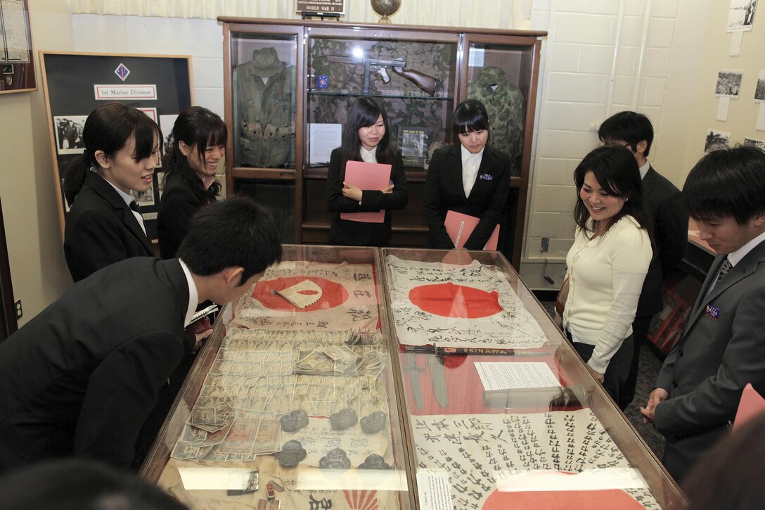 Urasoe City Hall employees view a part of the Battle of Okinawa Historical Society display during an orientation day on Camp Kinser April 4. The employees toured areas on Camp Kinser such as the display and the helicopter landing pad. The tour helped foster a professional working relationship between Urasoe City Hall administrators and service members and staff assigned to Camp Kinser. Photo by Lance Cpl. Anne K. Henry