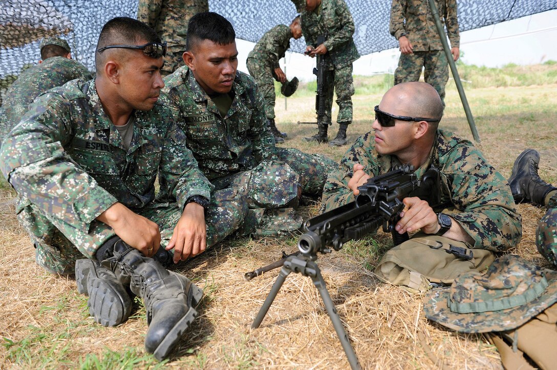 From left to right: Philippine Marine Cpls. Milky Espere and Raymond Almonte receive a familiarization brief from U.S. Marine Lance Cpl. Adrian Sandoval on how to disassemble an M249 squad automatic weapon April 5 during a bilateral subject-matter expert exchange at Camp O'Donnell, Republic of the Philippines. Espere and Almonte are with transportation and maintenance, Philippine Marine Corps. Sandoval is a supply clerk with Combat Logistics Regiment 35, 3rd Marine Logistics Group, III Marine Expeditionary Force. Photo by Tech. Sgt. Jerome S. Tayborn
