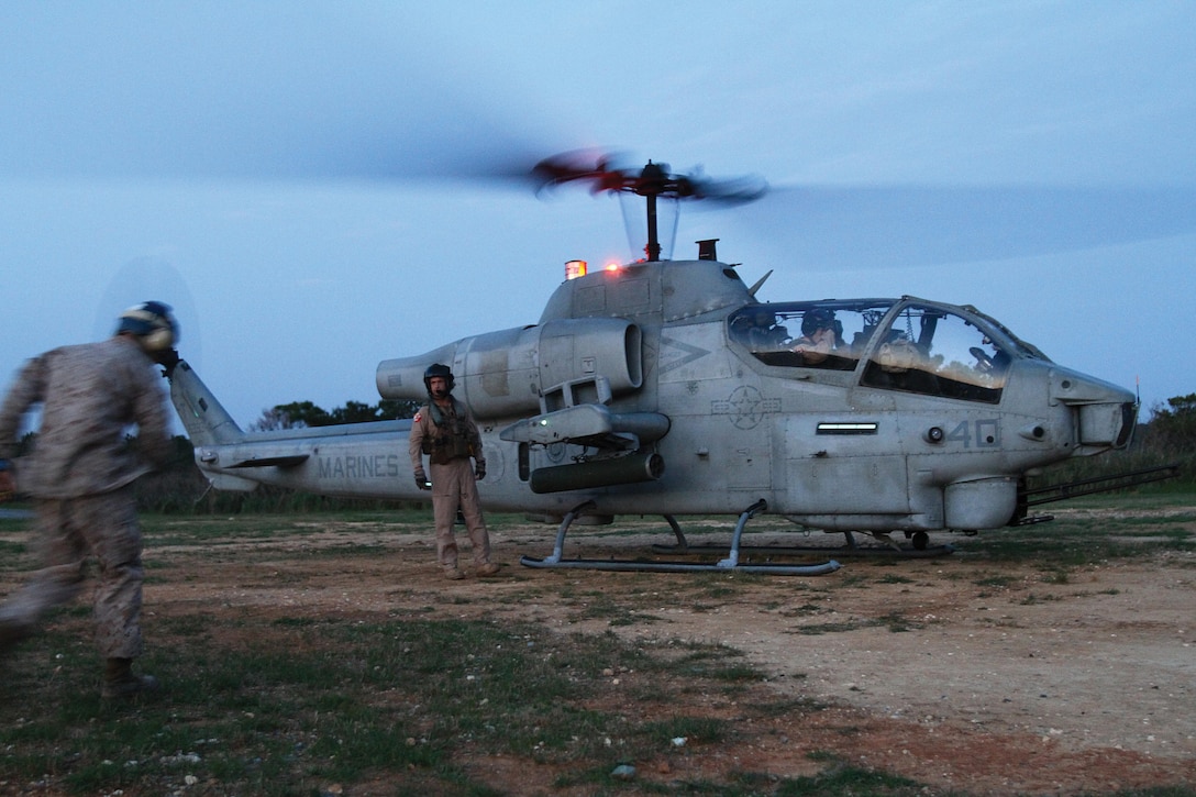 Marines prepare to refuel an AH-1W Super Cobra helicopter during a forward-arming and refueling point training exercise April 3 at the Central Training Area. Upon landing, the Cobra was refueled as part of an exercise to familiarize Marines with the procedures for refueling a helicopter while the engine is still running in order to expedite the aircraft’s return to the air. The helicopter is a part of HMM-262. Photo by Lance Cpl. Nicholas S. Ranum