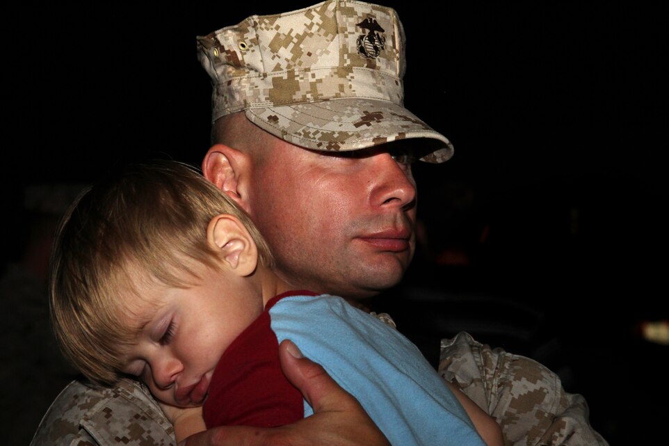 Warrant Officer Maseo Flores, motor transport maintenance officer, Support Company, 3rd Combat Engineer Battalion, says goodbye to his son, Devin, 2, March 30.