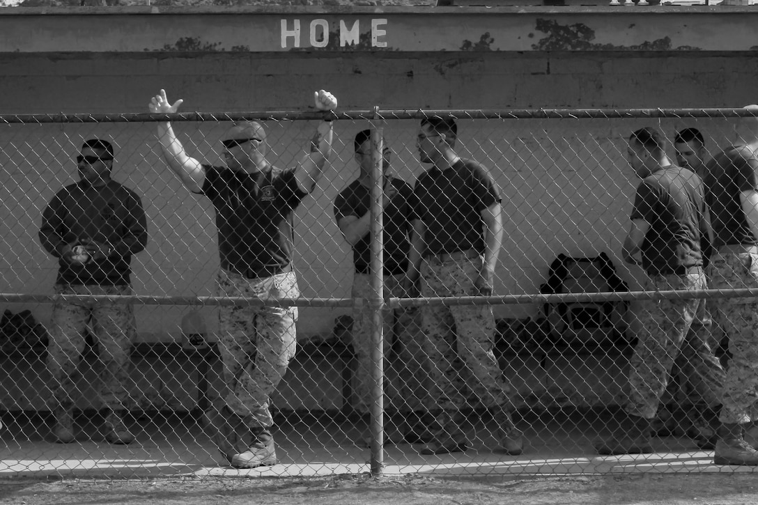 Marines and sailors of Combat Logistics Battalion 7 and their families hang out in the dug out  during a softball game during the unit's field meet and family day events at Del Valle Field March 28, 2013. Marines and sailors of CLB-7 competed against each other in a variety of events testing their speed, strength and endurance. 