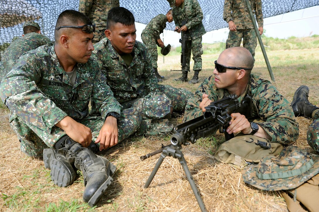 From left to right: Philippine Marine Cpl. Milky Espere and Cpl. Raymond Almonte, with the Philippine Transportation and Maintenance, observe U.S. Marine Lance Cpl. Adrian Sandoval, with Combat Logistics Regiment 35, 3rd Marine Logistics Group, III Marine Expeditionary Force, as he demonstrates how to disassemble a M240 machine gun April 5 during a bilateral subject matter expert exchange at a field training exercise in support of Balikatan 2013 at Camp O'Donnell, Philippines. BK13 is an annual bilateral exercise between the Armed Forces of the Philippines and U.S. forces to enhance interoperability, improve military-to-military relations, and refine combined and joint-force planning in response to humanitarian assistance and disaster relief operations.