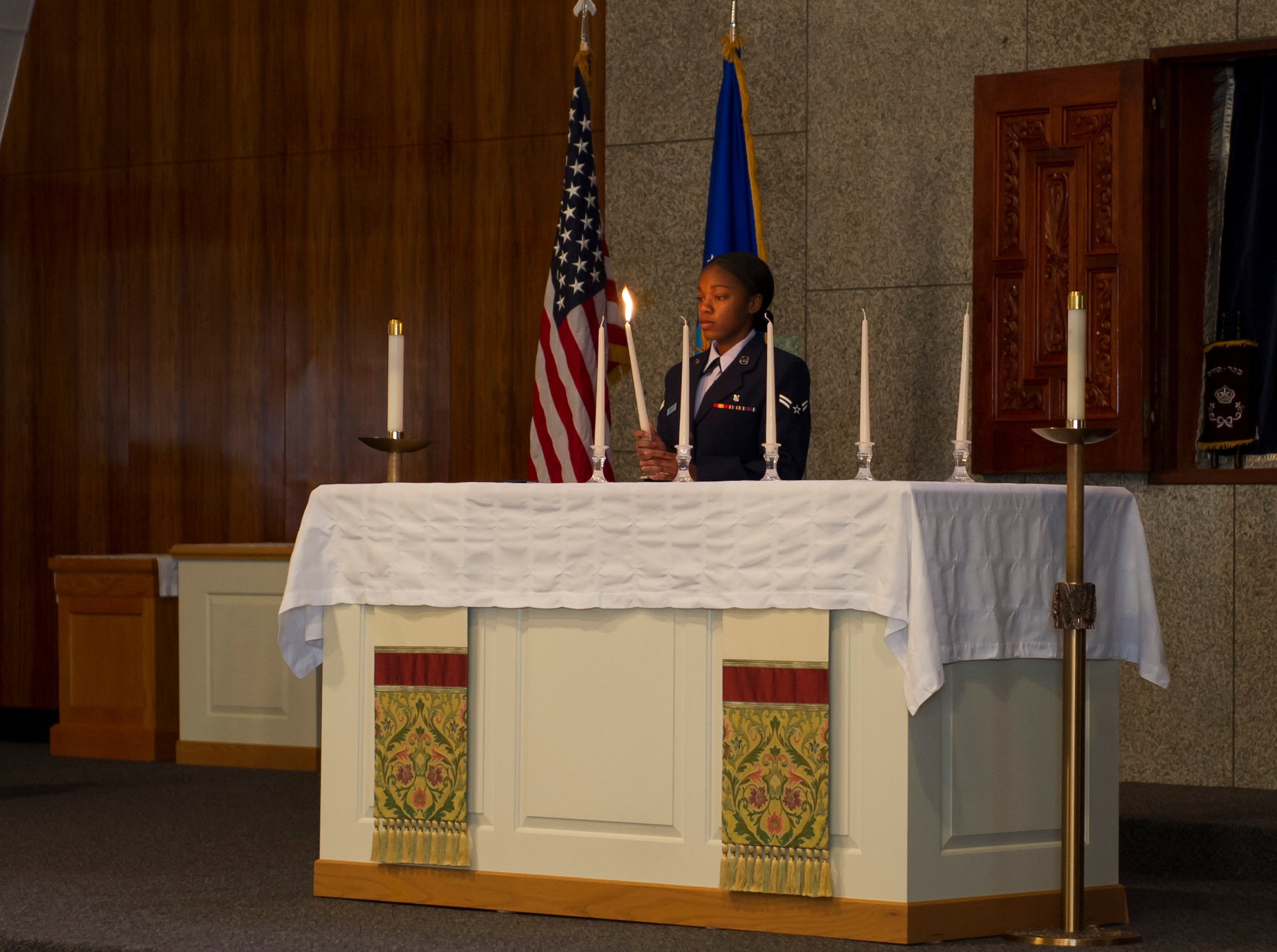 YOKOTA AIR BASE, Japan -- Airman 1st Class Rayonna Robinson, 374th Dental Squadron, lights candles during the 2013 Days of Remembrance Commemoration Ceremony held at the base chapel, Yokota Air Base, Japan, April 11, 2013. Holocaust Remembrance week is April 7-14, 2013.  Congress established the Days of Remembrance as the nation's annual commemoration of the Holocaust and created the United States Holocaust Memorial Museum as a permanent living memorial to the victims. The theme designated by the USHMM for the 2013 observance is "Never Again:  Heeding the Warning Signs." The goal of this year's DoR is to look back 75 years at the events of 1938 and examine how citizens and countries responded to signs of impending war and the Holocaust. (U.S. Air Force photo by Senior Airman Andrea Salazar/Released)