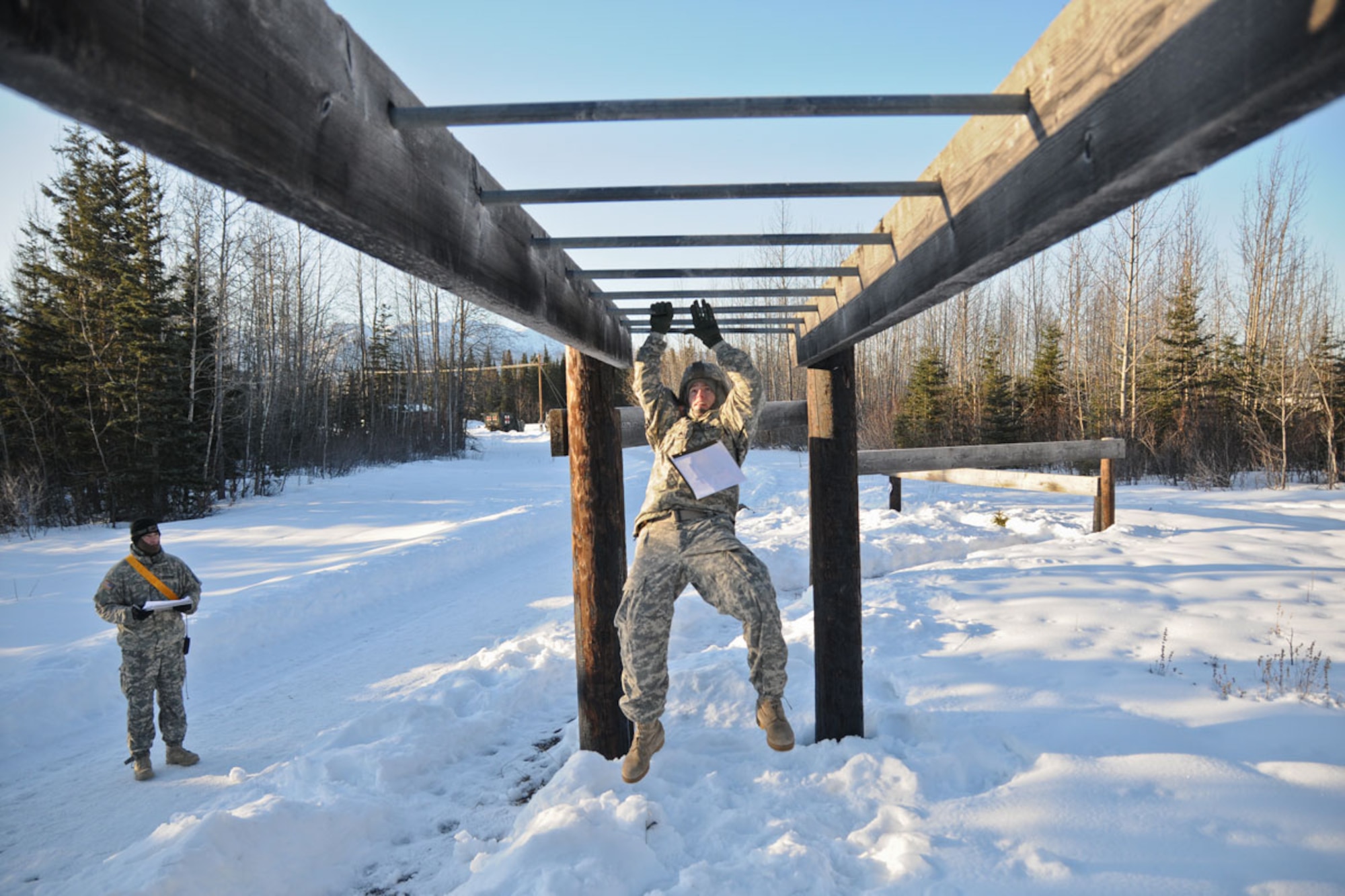 Army Staff Sgt. Jason Dean, a paratrooper assigned to the 725th Brigade Support Battalion, crosses the climbing bars on the “Tarzan” during the Best Junior Leader Competition on JBER April 2. The “Tarzan” is one of 10 obstacles paratroopers complete during the Confidence Course. (U.S. Army photo/Sgt. 1st Class Jason Epperson)