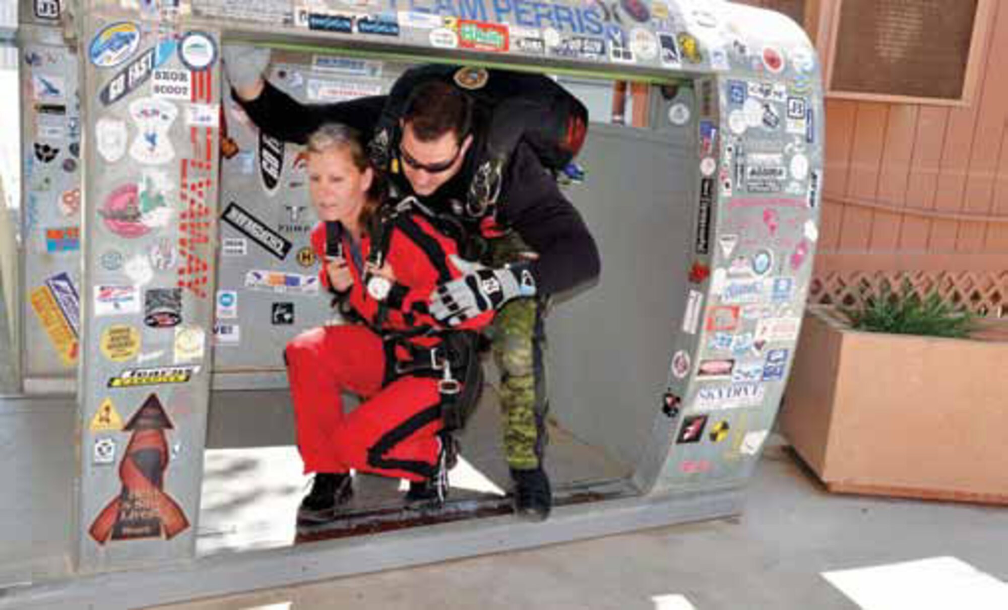Master Sgt. Kelly Lundgrin, 452 Air Mobility Wing is shown how to properly exit the
airplane door prior to taking her turn at skydiving with the Les SkyHawks, April 2. The SkyHawks are the Canadian Army’s premier parachute demonstration team,that travels to Perris, Calif., to practice their skydiving skills and routines. (U.S. Air Force photo by Darnell Gardner)
