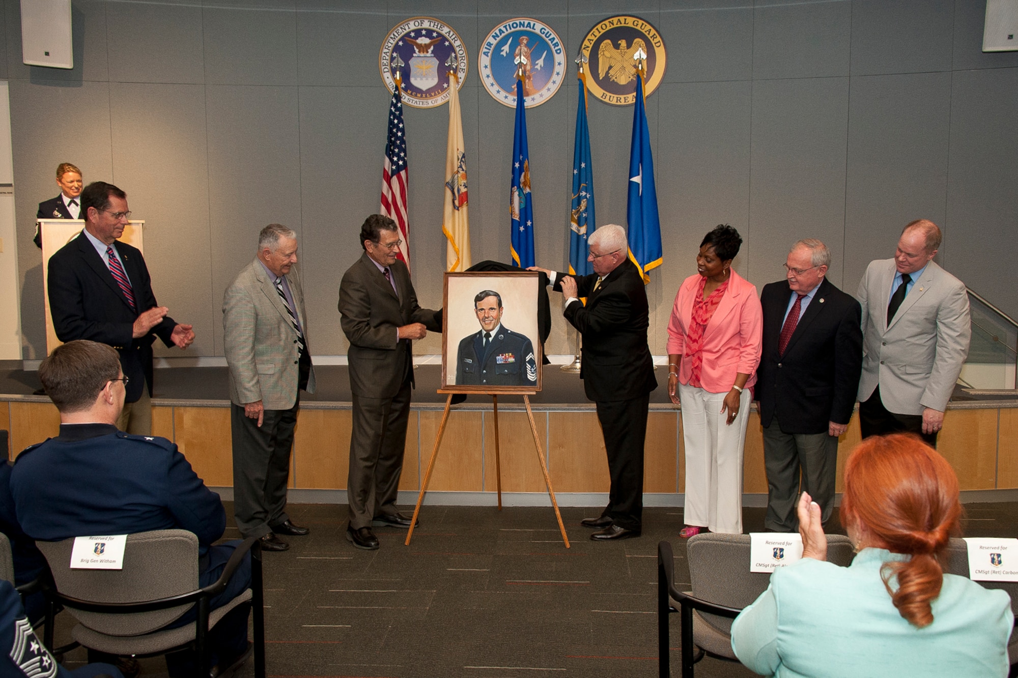 (Left to right) Retired Air Force chief master sergeants Richard Green, Bernard Carbon, Ed Brown, Valerie Benton, Dick Smith, and Chris Muncy unveil a portrait of Chief Master Sgt. Theodore H. Jackson during the Chief Jackson Memorial Auditorium dedication ceremony April 11, 2013, at the Air National Guard Readiness Center, Joint Base Andrews, Md. Jackson was the first appointed senior enlisted adviser to the director of the Air National Guard and became a recognized spokesman for ANG enlisted personnel on welfare and morale matters. (National Guard photo by Master Sgt. Marvin R. Preston)