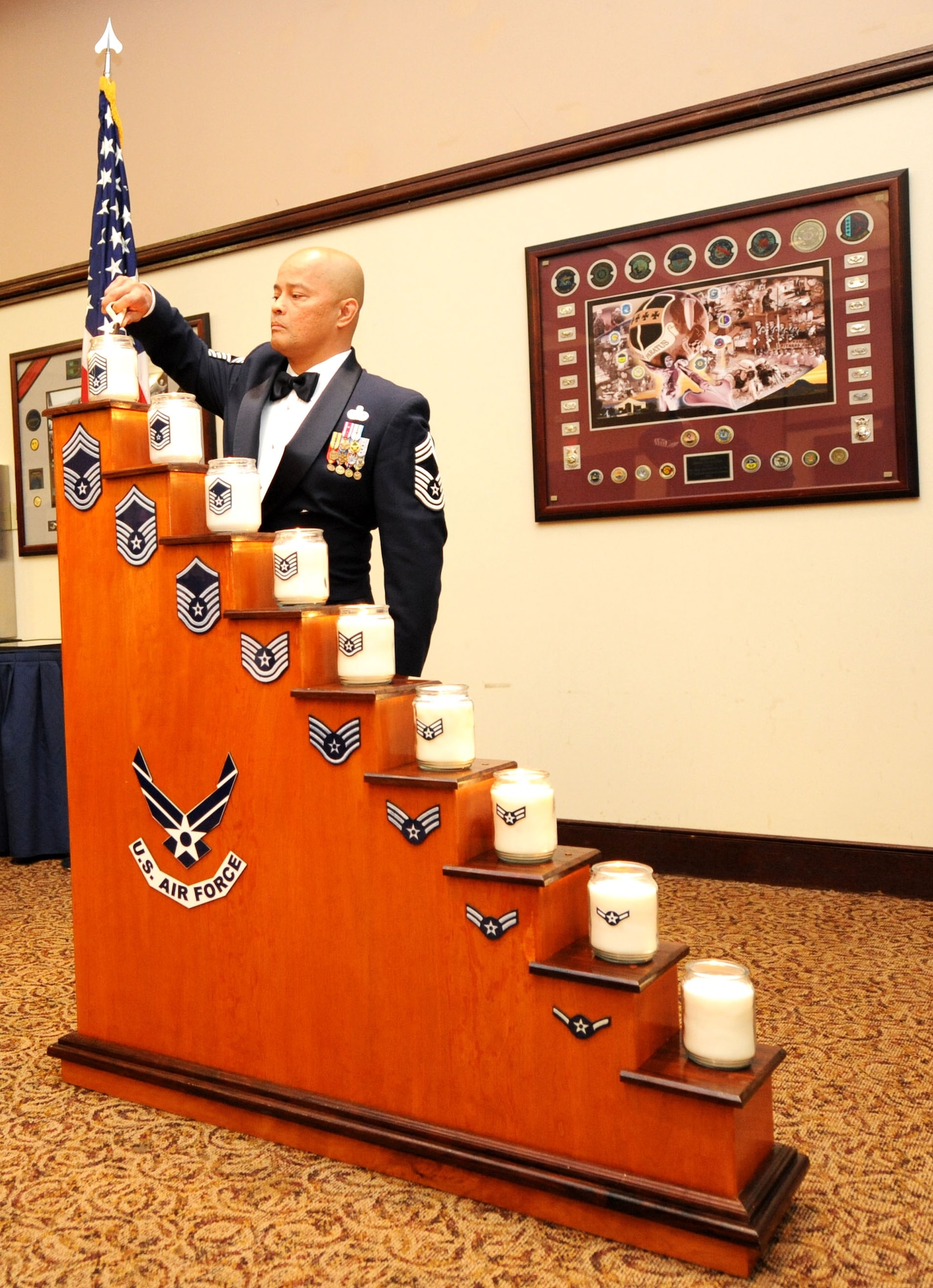Chief Master Sgt. Glenn Taijeron, 9th Communications Squadron chief enlisted manager, lights the candle representing the rank of chief master sergeant during the Chief’s Recognition Ceremony at the Recce Point Club on Beale Air Force Base, Calif., April 8, 2013. The candle lighting represents an Airman’s journey through the enlisted ranks. (U.S. Air Force photo by Airman 1st Class Bobby Cummings/Released)