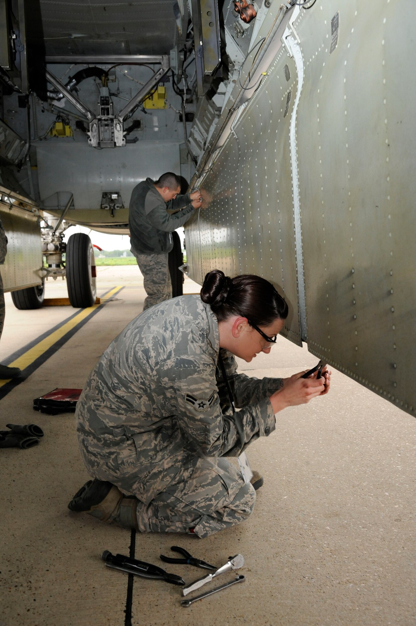 Airman 1st Class Sarah Sandage, 2nd Maintenance Squadron Accessories Flight Hydraulics, and Airman 1st Class Ronald Roberts, 2 MXS Accessories Flight Hydraulics, disconnect the bomb door deflection joint links of a B-52H Stratofortress during a bomb door operations check on Barksdale Air Force Base, La., April 11, 2013. Disconnecting the doors will allow the Airmen to perform a bomb door operations check without damaging the doors. (U.S. Air Force photo/Airman 1st Class Andrew Moua)
