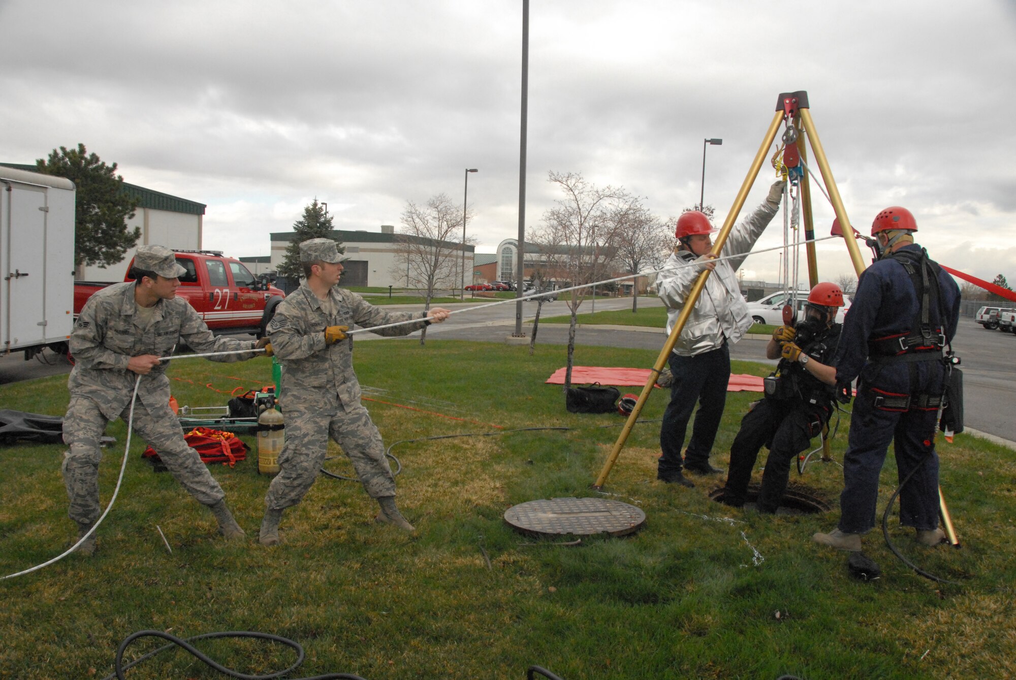 Firefighters with the 151st Air Refueling Wing participate in a confined space emergency rescue exercise April 11, 2013.  A mannequin lowered into a manhole served as a victim that Staff Sgt. Leo Jensen and Staff Sgt. Thomas Beck rescued.  Training exercises like this occur annually, allowing Guardsmen the chance to keep their abilities up to date, and to be prepared for any emergency.  (U.S. Air Force Photo by A1C Emily Hulse/Released)