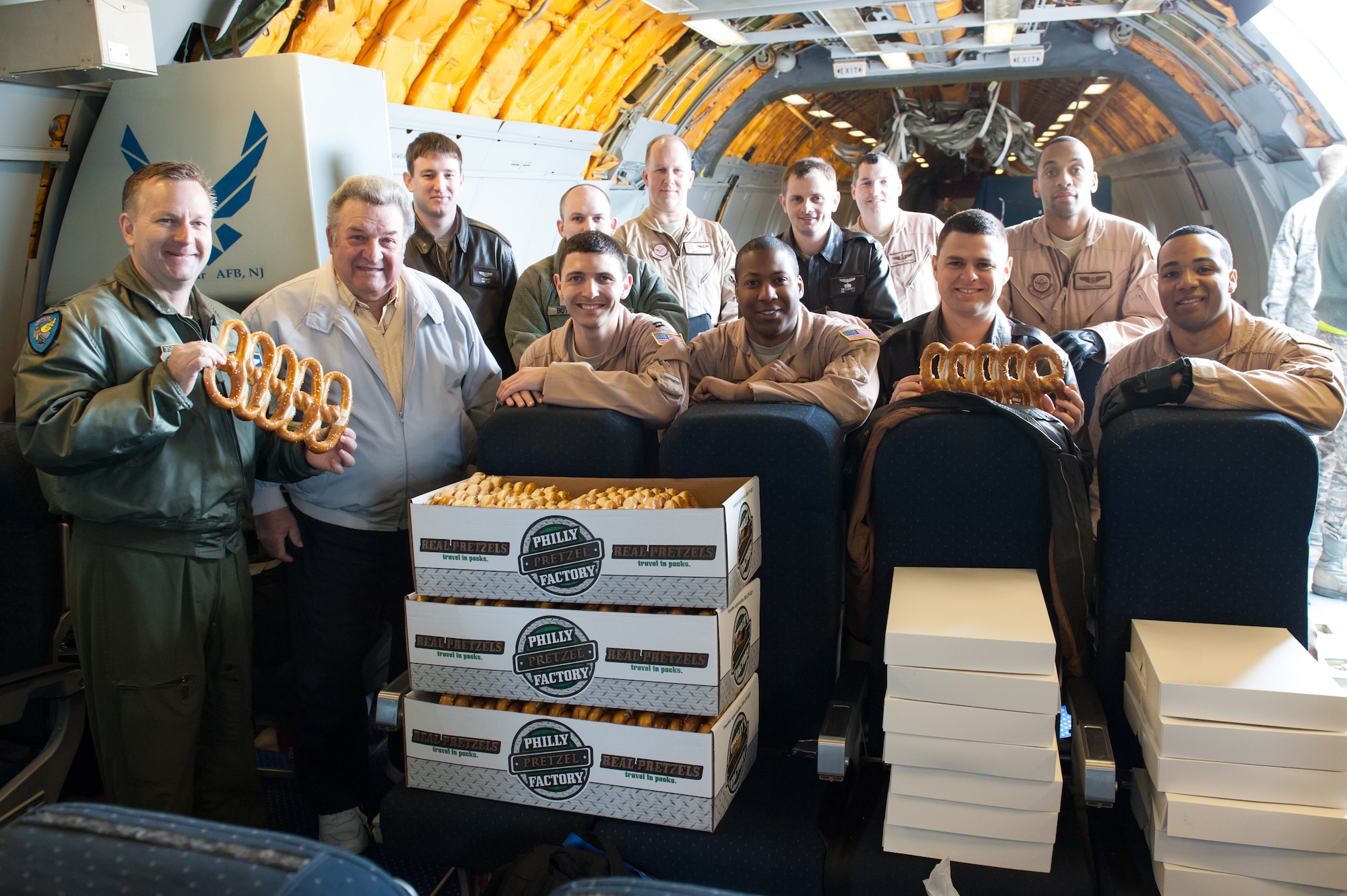 Col. Rick Williamson, 305th Air Mobility Wing commander, and Joe Zarzaca, 32nd Air Refueling Squadron honorary squadron commander, pose in a group photo with deploying members of the 32nd ARS aboard a KC-10 Extender on Joint Base McGuire-Dix-Lakehurst, N.J., March 26, 2013. Zarzaca delivered more than 1,000 bagels and doughnuts to each deploying KC-10.  (U.S. Air Force photo by Russ Meseroll/Released)