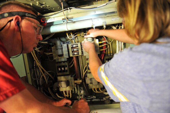 Harris Miller, 402nd Aircraft Maintenance Group, and Lisa Wood, 560th Aircraft Maintenance Squadron, perform electrical modifications to a C-130 in service at Robins. (U.S. Air Force photo by Tommie Horton)