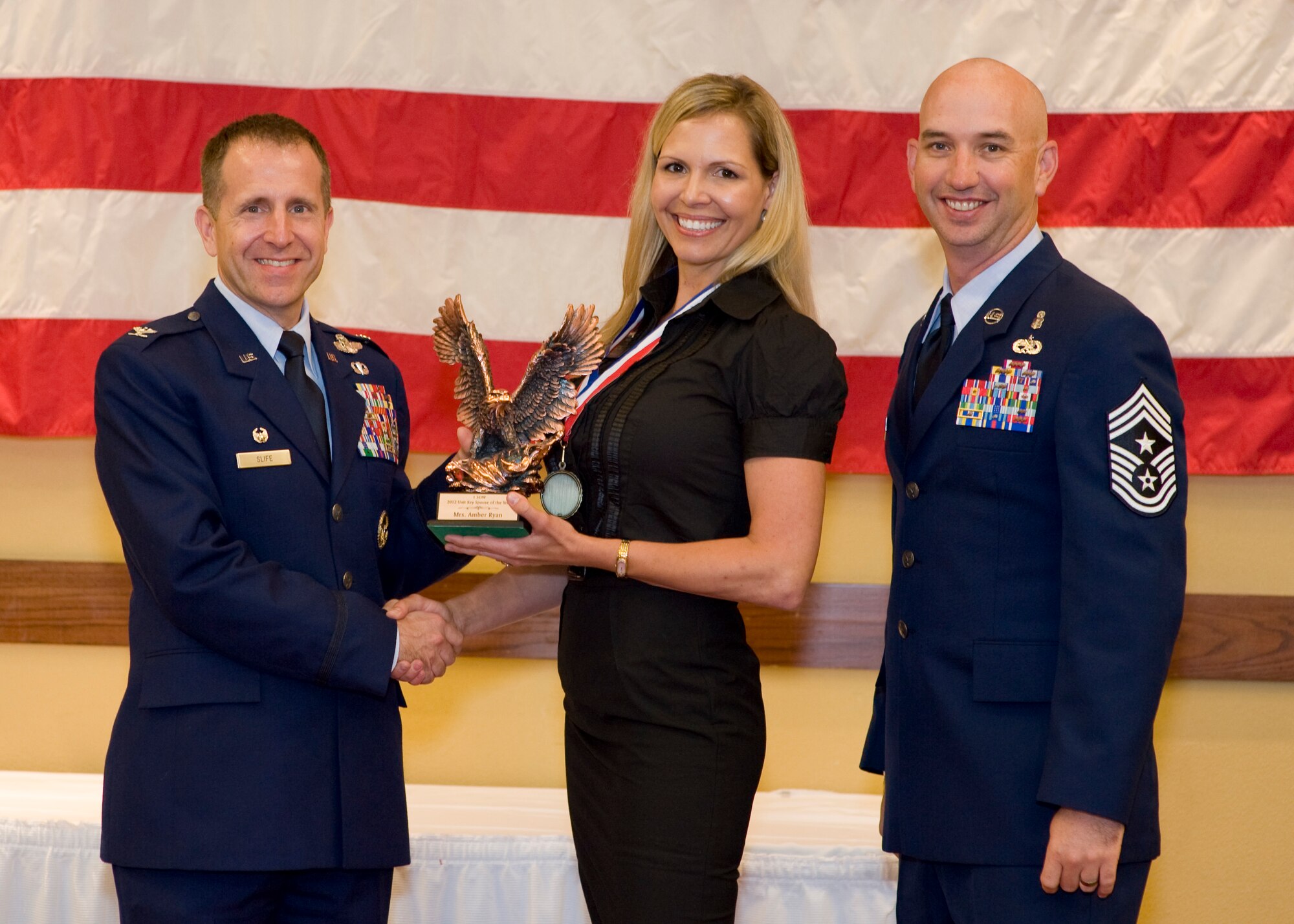 Col. Jim Slife, commander of 1st Special Operations Wing, left, and Chief Master Sgt. Jeff Maberry, command chief of 1st SOW, right, present Amber Ryan, wife of Capt. Tommy Ryan of 9th Special Operations Squadron, center, with the 1st SOW Key Spouse of the Year award at the 2012 1st SOW Annual Awards Luncheon at the Soundside Club at Hurlburt Field, Fla., April 11, 2013. (U.S. Air Force photo by Airman 1st Class Christopher Callaway)
