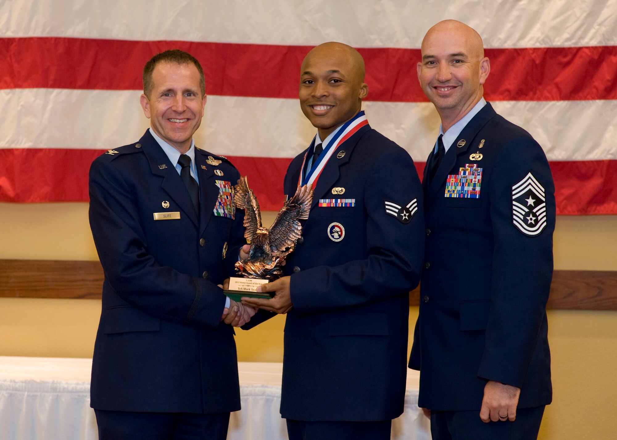 Col. Jim Slife, commander of 1st Special Operations Wing, left, and Chief Master Sgt. Jeff Maberry, command chief of 1st SOW, right, present Senior Airman Mark Seay, 1st Special Operations Force Support Squadron, center, with the 1st SOW Ceremonial Guardsman of the Year award at the 2012 1st SOW Annual Awards Luncheon at the Soundside Club at Hurlburt Field, Fla., April 11, 2013. (U.S. Air Force photo by Airman 1st Class Christopher Callaway)