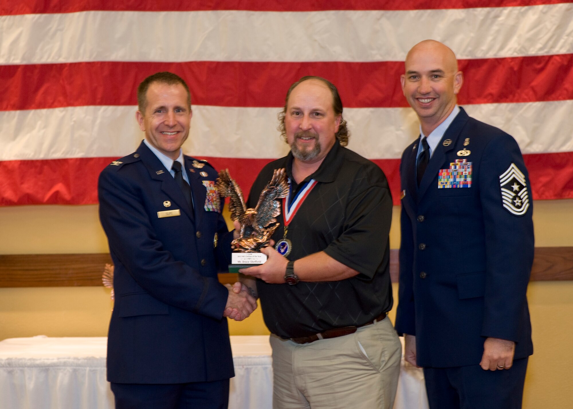 Col. Jim Slife, commander of 1st Special Operations Wing, left, and Chief Master Sgt. Jeff Maberry, command chief of 1st SOW, right, present Bruce Sheffield, 1st Special Operations Support Squadron, center, with the 1st SOW Wage Grade Civilian of the Year award at the 2012 1st SOW Annual Awards Luncheon at the Soundside Club at Hurlburt Field, Fla., April 11, 2013. (U.S. Air Force photo by Airman 1st Class Christopher Callaway)