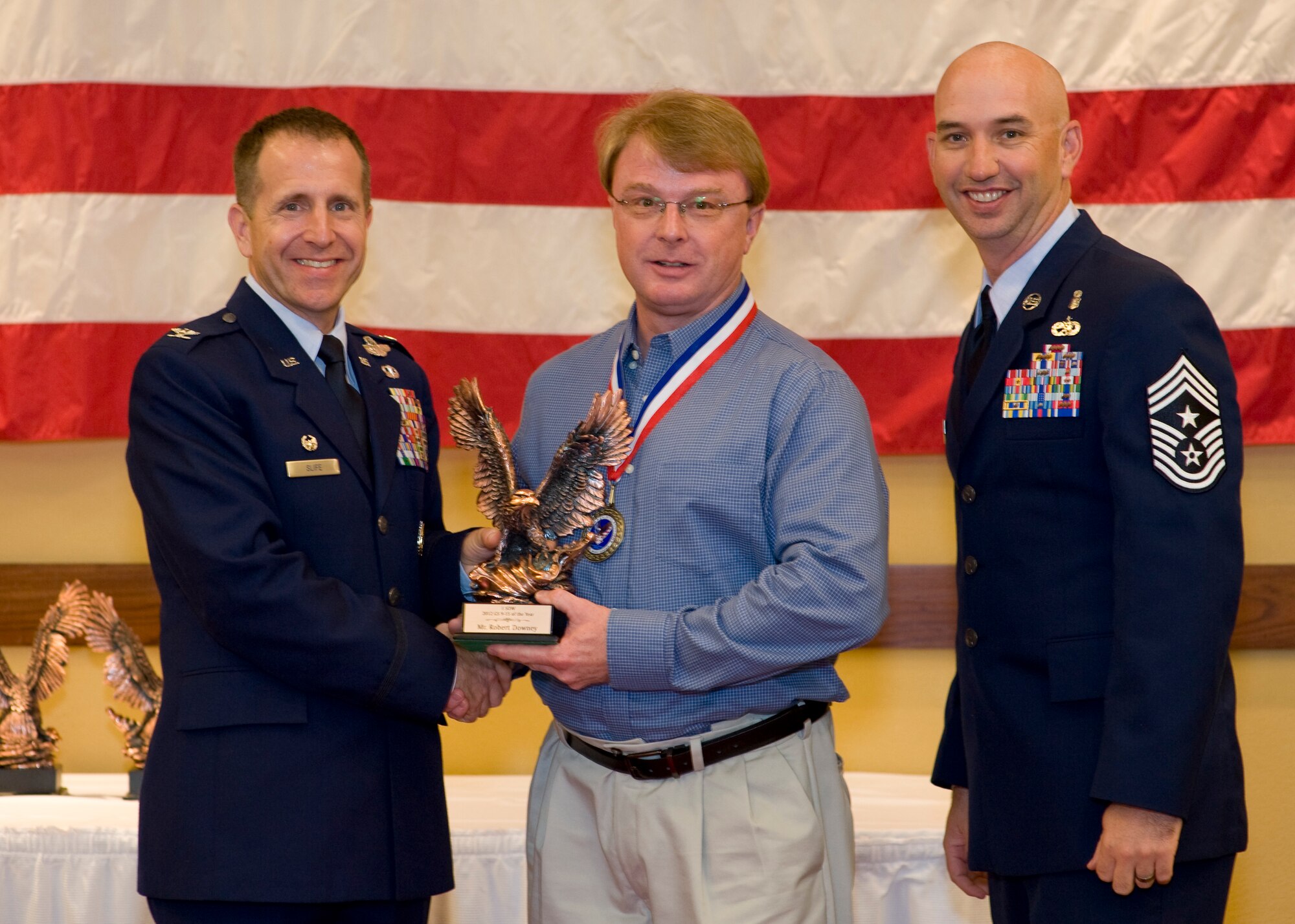 Col. Jim Slife, commander of 1st Special Operations Wing, left, and Chief Master Sgt. Jeff Maberry, command chief of 1st SOW, right, present Robert Downey, airfield manager of 1st Special Operations Support Squadron, center, with the 1st SOW GS 9-12 Civilian of the Year award at the 2012 1st SOW Annual Awards Luncheon at the Soundside Club at Hurlburt Field, Fla., April 11, 2013. (U.S. Air Force photo by Airman 1st Class Christopher Callaway)