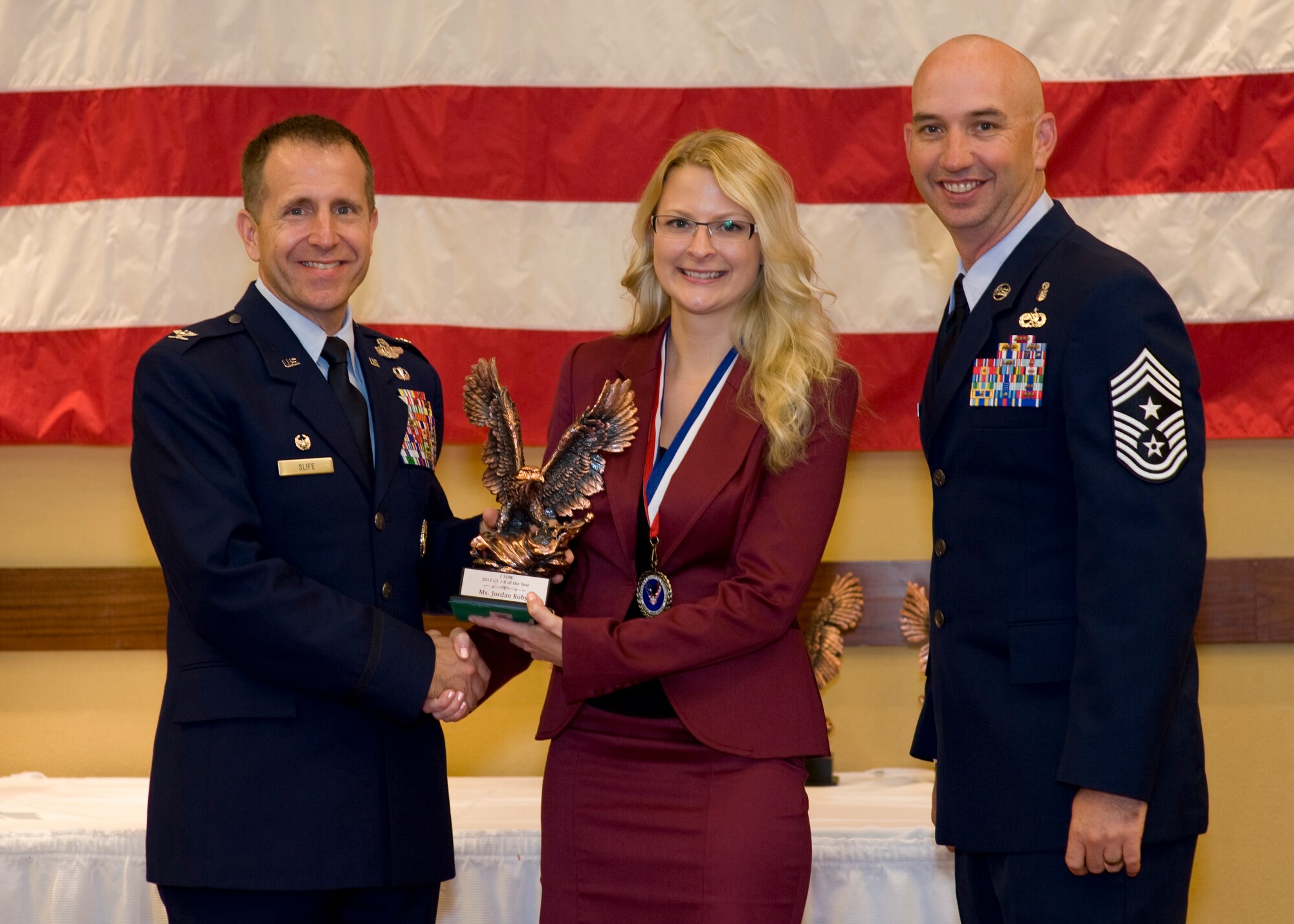 Col. Jim Slife, commander of 1st Special Operations Wing, left, and Chief Master Sgt. Jeff Maberry, command chief of 1st SOW, right, present Jordan Roby, a contracting specialist of 1st Special Operations Contracting Squadron, center, with the 1st SOW GS 1-8 Civilian of the Year award at the 2012 1st SOW Annual Awards Luncheon at the Soundside Club at Hurlburt Field, Fla., April 11, 2013. (U.S. Air Force photo by Airman 1st Class Christopher Callaway)
