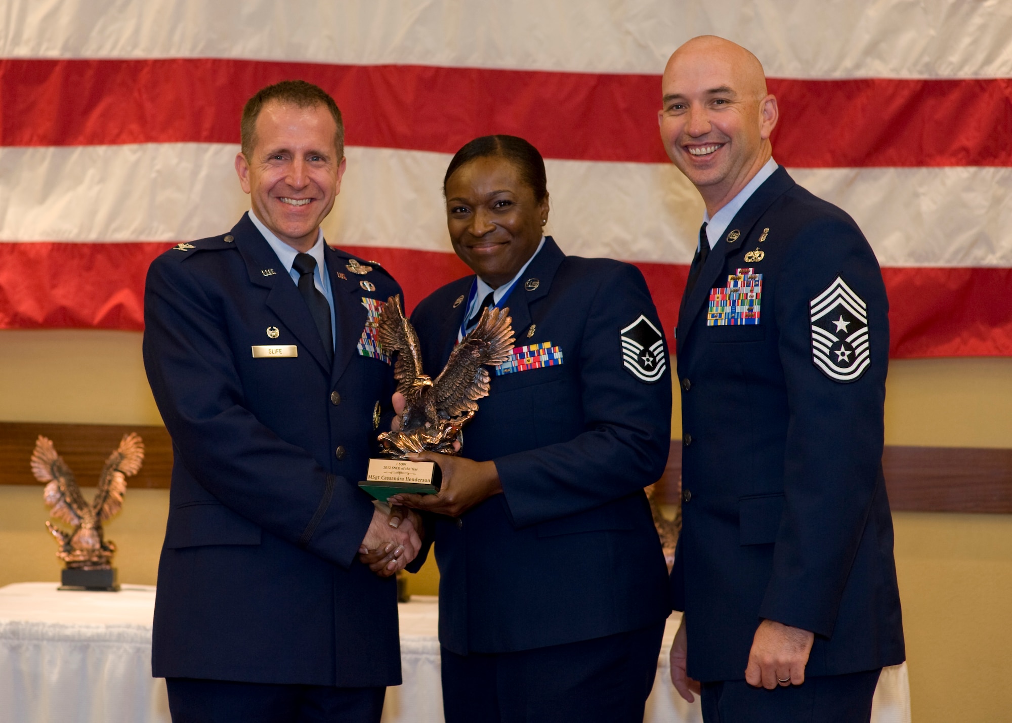 Col. Jim Slife, commander of 1st Special Operations Wing, left, and Chief Master Sgt. Jeff Maberry, command chief of 1st SOW, right, present Master Sgt. Cassandra Henderson, superintendent of 1st Special Operations Dental Squadron, center, with the 1st SOW Senior NCO of the Year award at the 2012 1st SOW Annual Awards Luncheon at the Soundside Club at Hurlburt Field, Fla., April 11, 2013. (U.S. Air Force photo by Airman 1st Class Christopher Callaway)